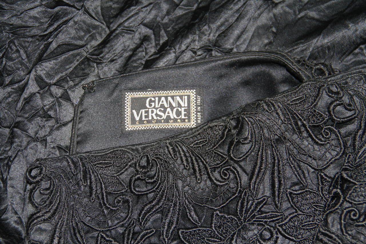 Gianni Versace black silk long skirt, with a side split and lace waistband from the Spring 1994 Punk collection. 

The skirt is permanently ceased to enhance the punk inspired look of the piece.

Marked an Italian size 42.

Manufacturer -