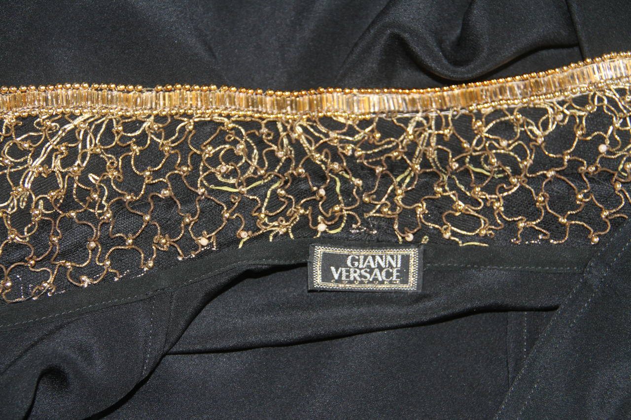 Gianni Versace black silk evening blouse from the Fall 1992 Bondage collection.

The blouse features gold metal and gold-tone bead detailing to the collar and sleeves.

Marked an Italian size 42.

Manufacturer - Alias S.p.a.

Fabric content