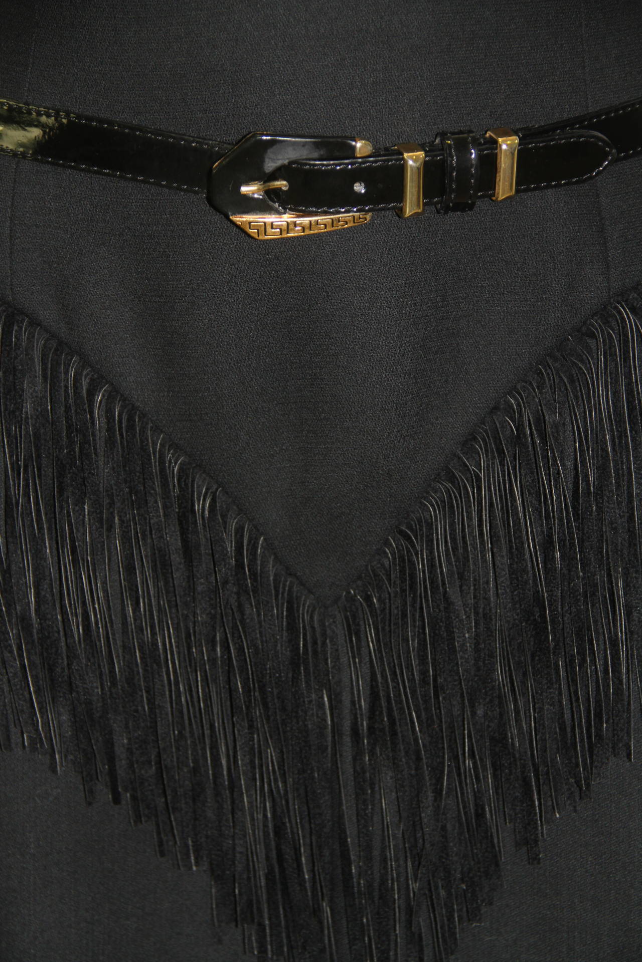 Very rare Atelier Versace black wool and suede leather fringed cowgirl skirt from the Fall 1992 Haute Couture Bondage collection, shown at The Ritz in Paris.

The skirt features suede fringing, together with a black leather belt, featuring Greca