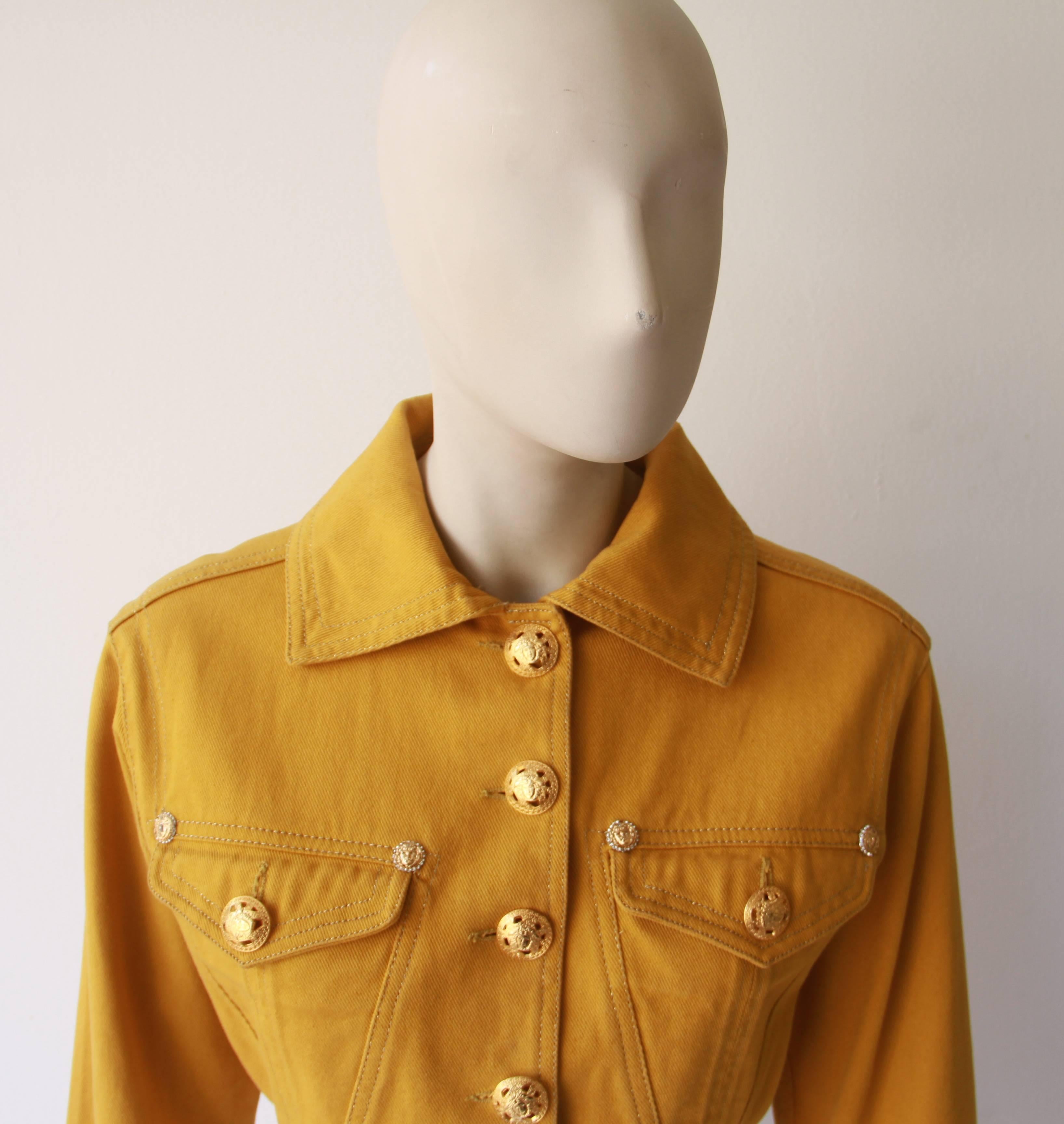 Gianni Versace gold yellow cropped cotton denim jacket from the Fall 1992 Versace Jeans Couture collection. 

The jacket features large gold-tone metal cut-out Medusa embossed buttons and smaller gold-tone metal and paste buttons to the