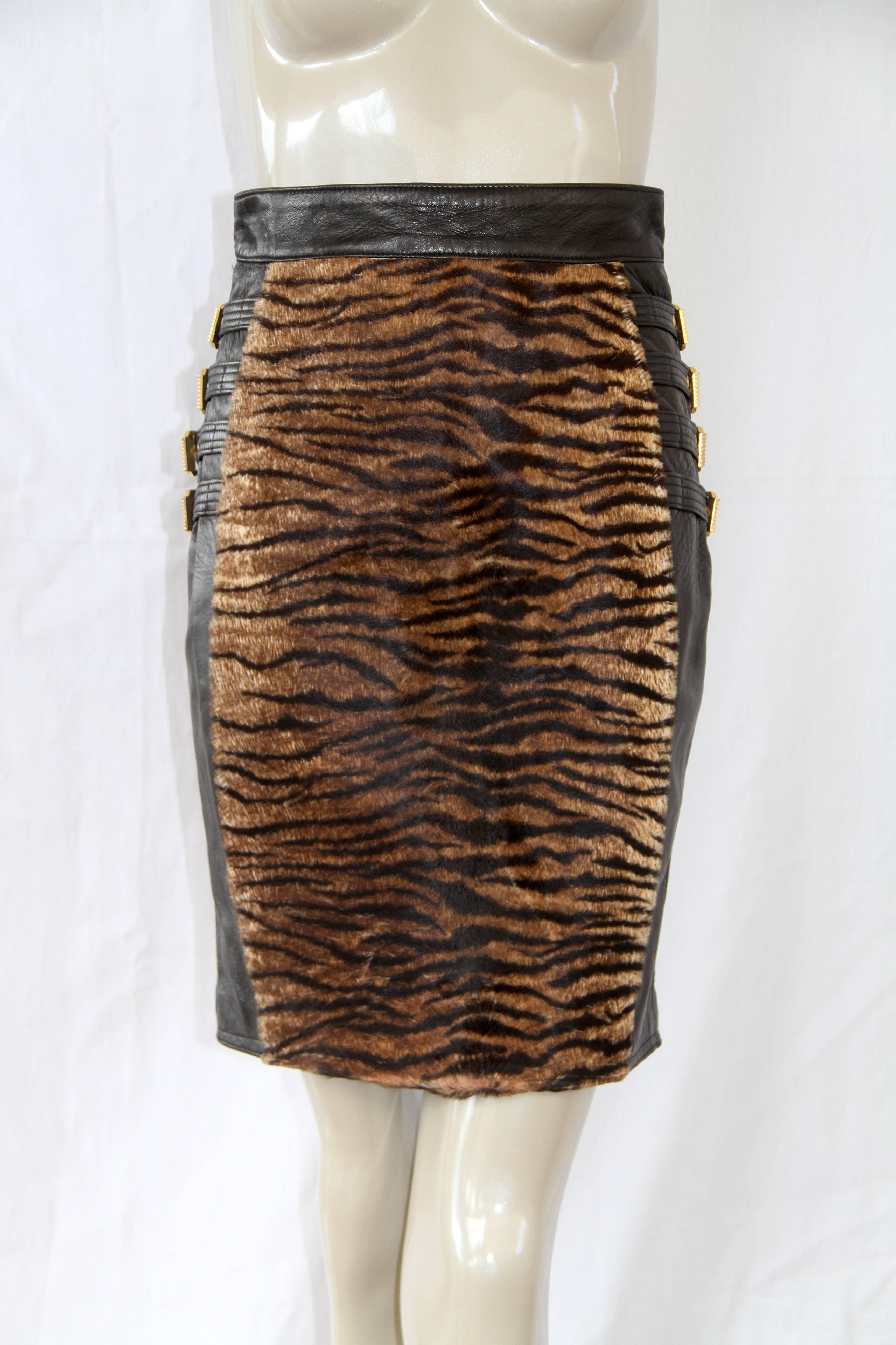 Gianni Versace leather and animal print fur skirt, with bondage buckle detailing, from the Fall 1992 Bondage collection.

Marked an Italian size 40.

Manufacturer - Ruffo S.p.a.

Fabric content - 100% leather