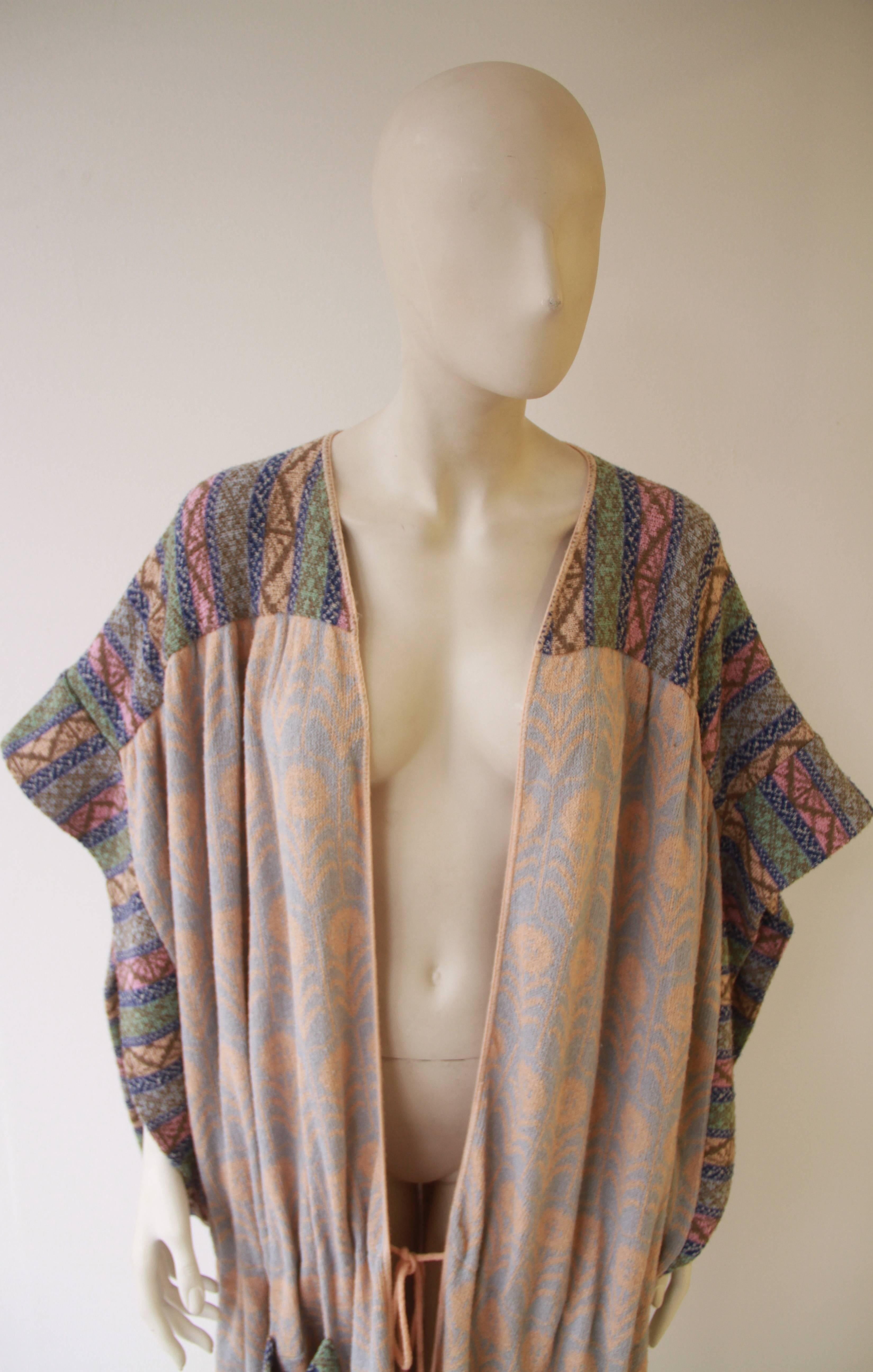 Museum quality and extremely rare Bill Gibb and Kaffe Fassett designed knitted voluminous cotton coat from 1975. The coat is knitted in a pale blue and peach pattern, with a multi-coloured knitted trim.

A similar shorter piece is part of the