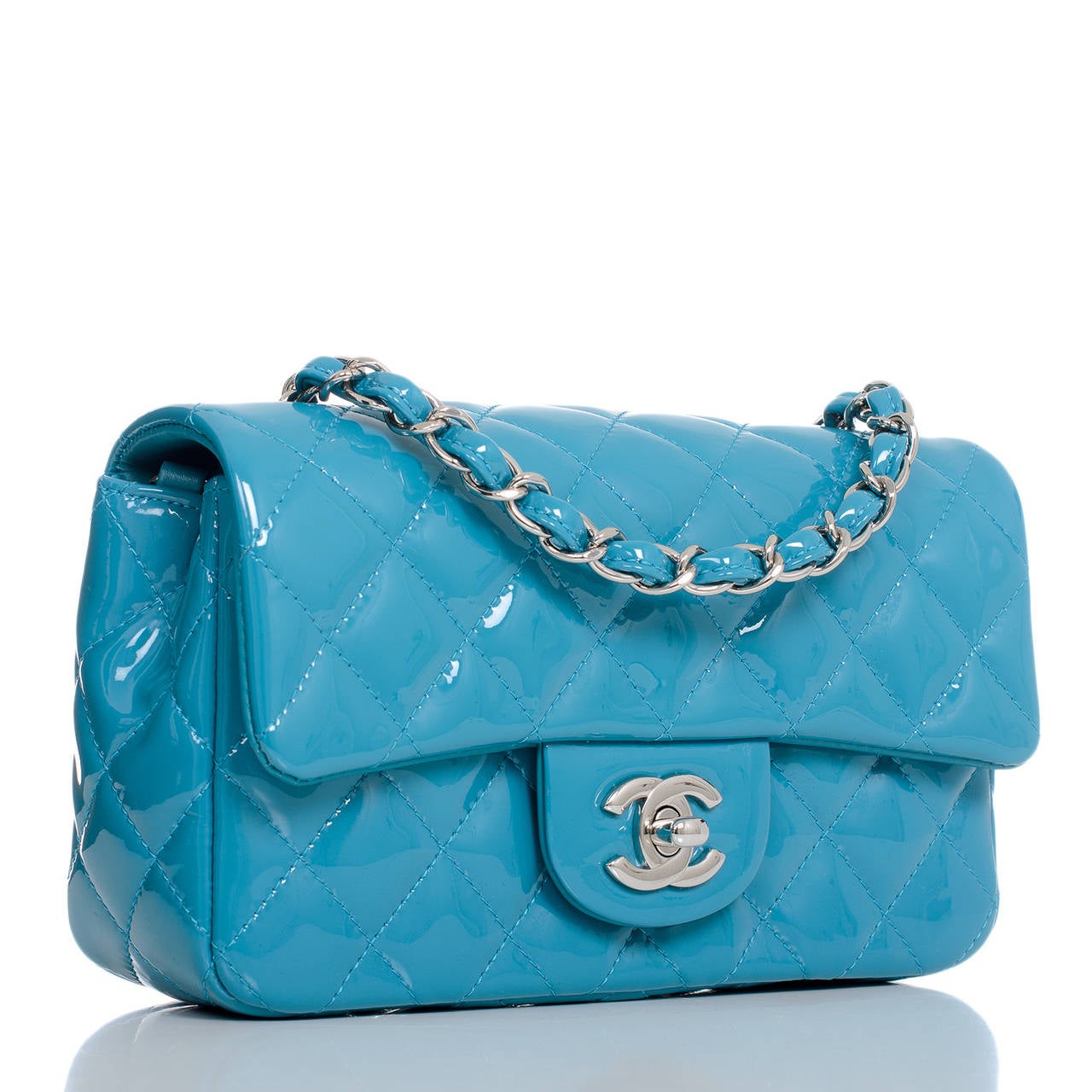 Chanel turquoise Small Classic flap bag in quilted patent leather with silver tone hardware.

This flap bag in turquoise quilted patent is the new small size -- compact and sophisticated with greater room than the crossbody mini or WOC. Worn on