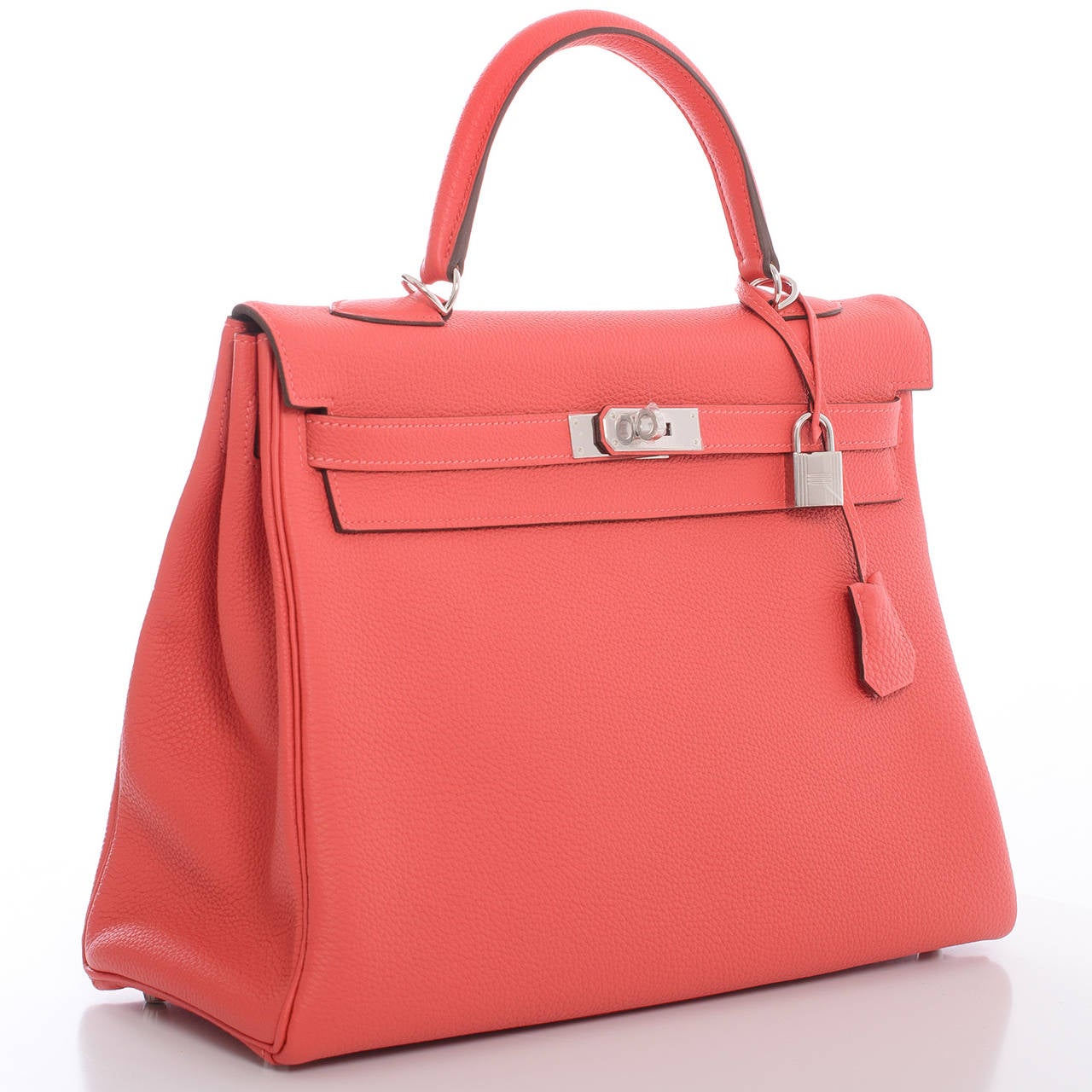 Hermes Rouge Pivoine Kelly 35cm in rich togo (bull) leather with palladium hardware.

The Hermes Kelly bag, like its sister bag -- the Birkin -- is a coveted and scarce bag. Like its muse, Grace Kelly, this bag is the definition of timeless