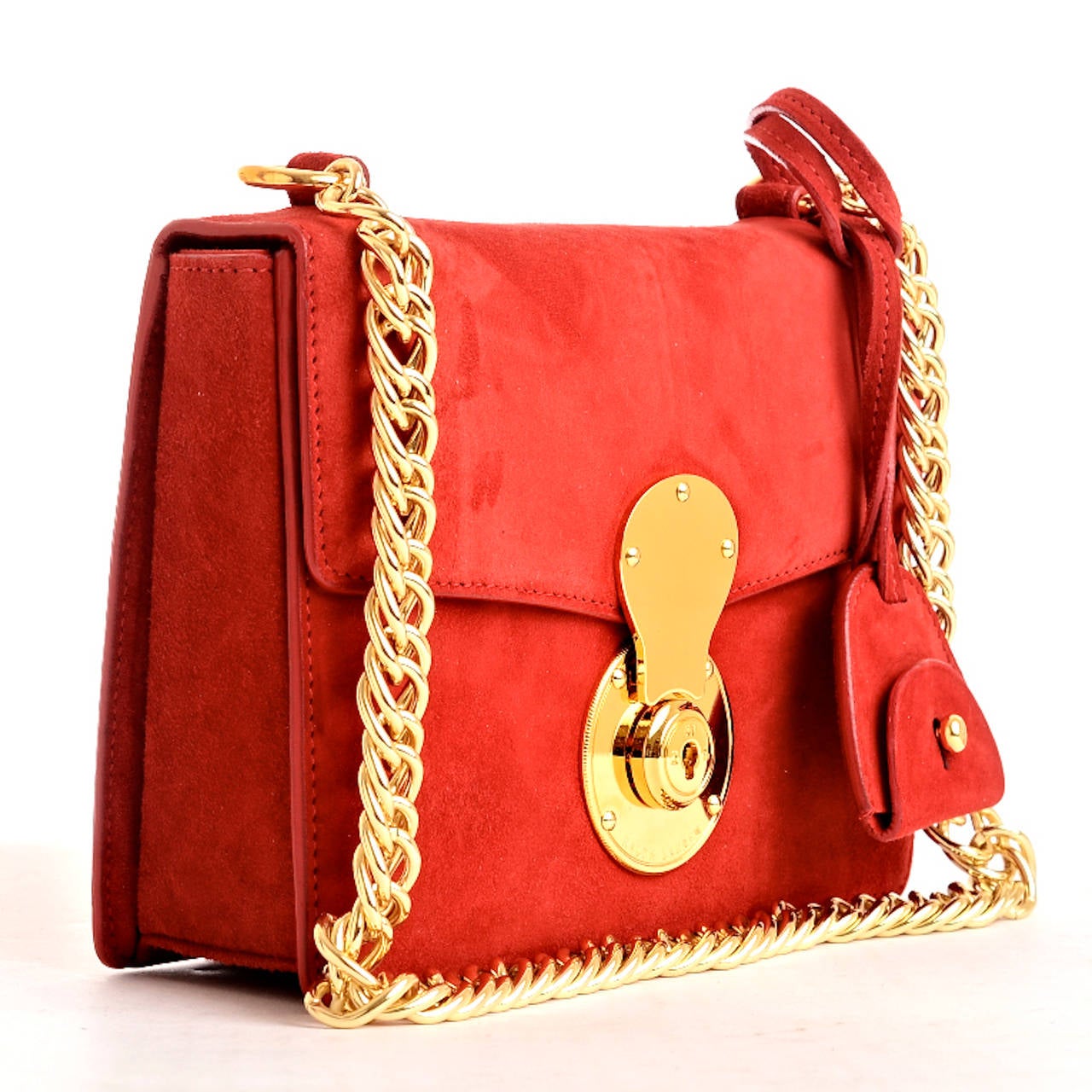 Ralph Lauren plush red suede Ricky Chain Bag with front flap with signature gold tone logo-embossed Ricky lock, matching removable key bell and gold tone chain link shoulder strap. Interior of black fabric with single open pocket on rear wall. 