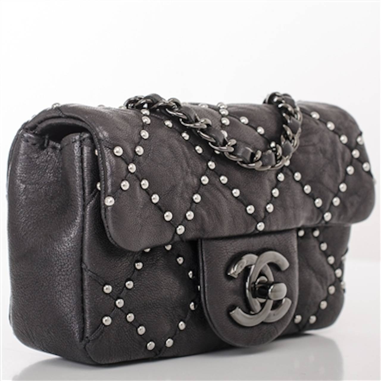 Chanel limited edition black Mini Studded flap bag of distressed lambskin leather with stud accents and aged ruthenium hardware.

Named 2.55 to honor the bag's creation in February 1955, the iconic Chanel bag was a modification of the bag Coco
