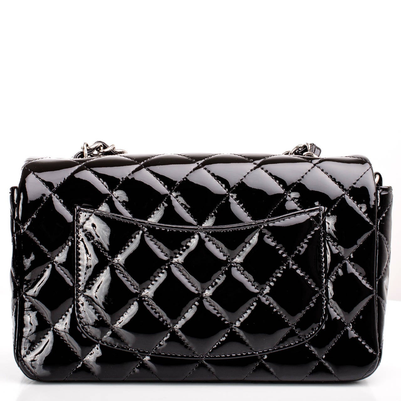 Chanel black Small Classic flap bag in quilted patent leather with silver tone hardware.

This flap bag in classic black quilted patent is the new small size -- compact and sophisticated with greater room than the crossbody mini or WOC. Worn on