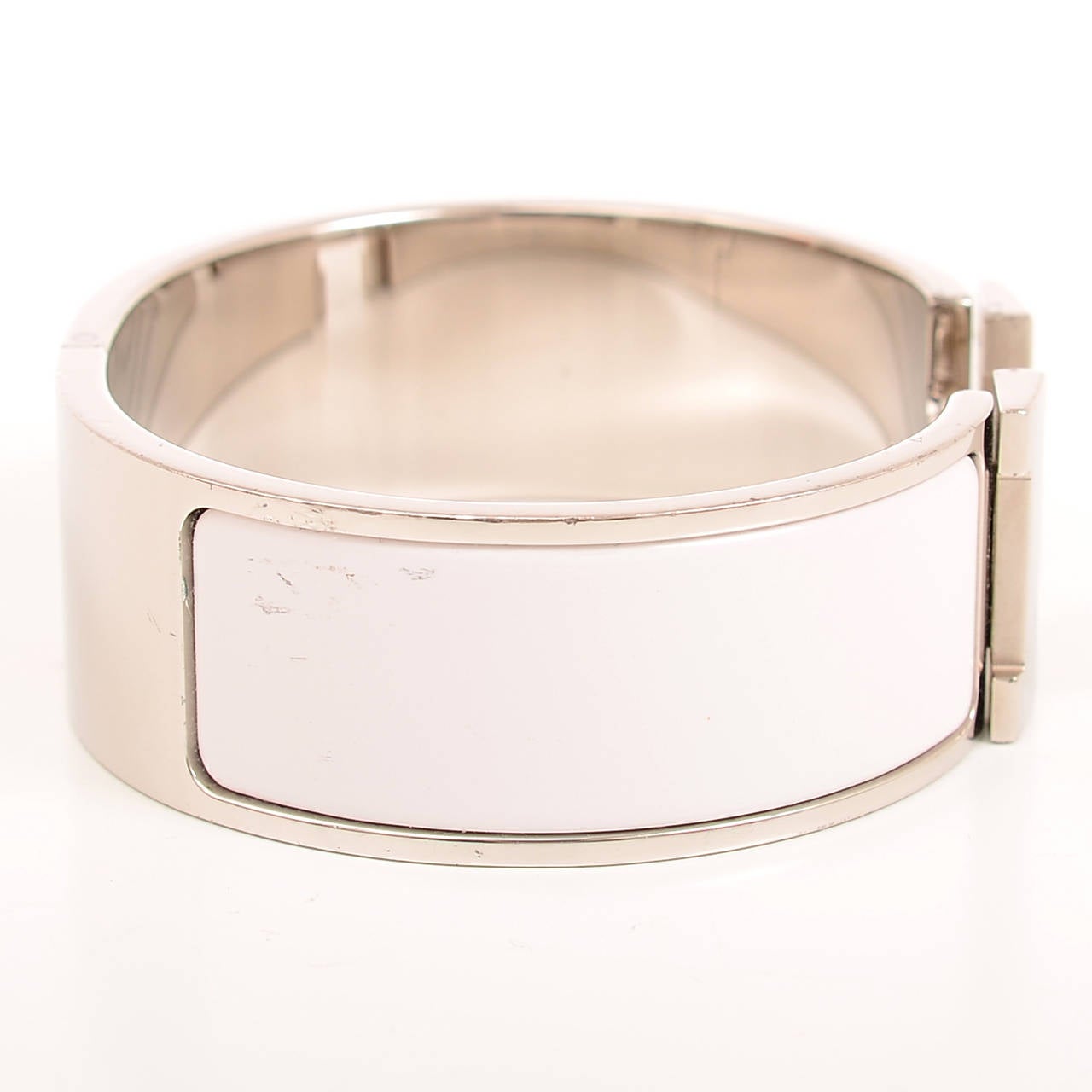 Hermes wide Clic Clac H bracelet in white enamel with palladium and silver plated hardware in size PM.

Hermes is renowned for its enamel and leather bracelets. Hermes printed enamel bangles, enamel Clic Clac H bracelets, and leather/exotic