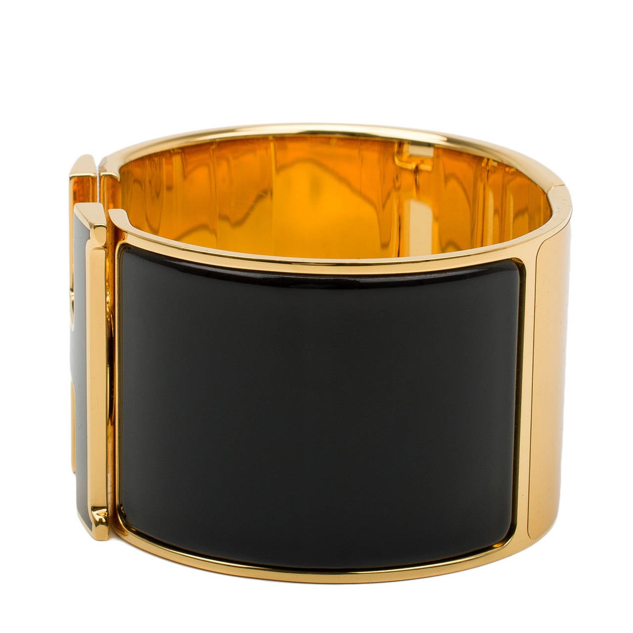 Hermes extra wide Clic Clac H bracelet in black with black enamel H closure with gold plated hardware in size PM.

Hermes is renowned for its enamel and leather bracelets. Hermes printed enamel bangles, enamel Clic Clac H bracelets, and