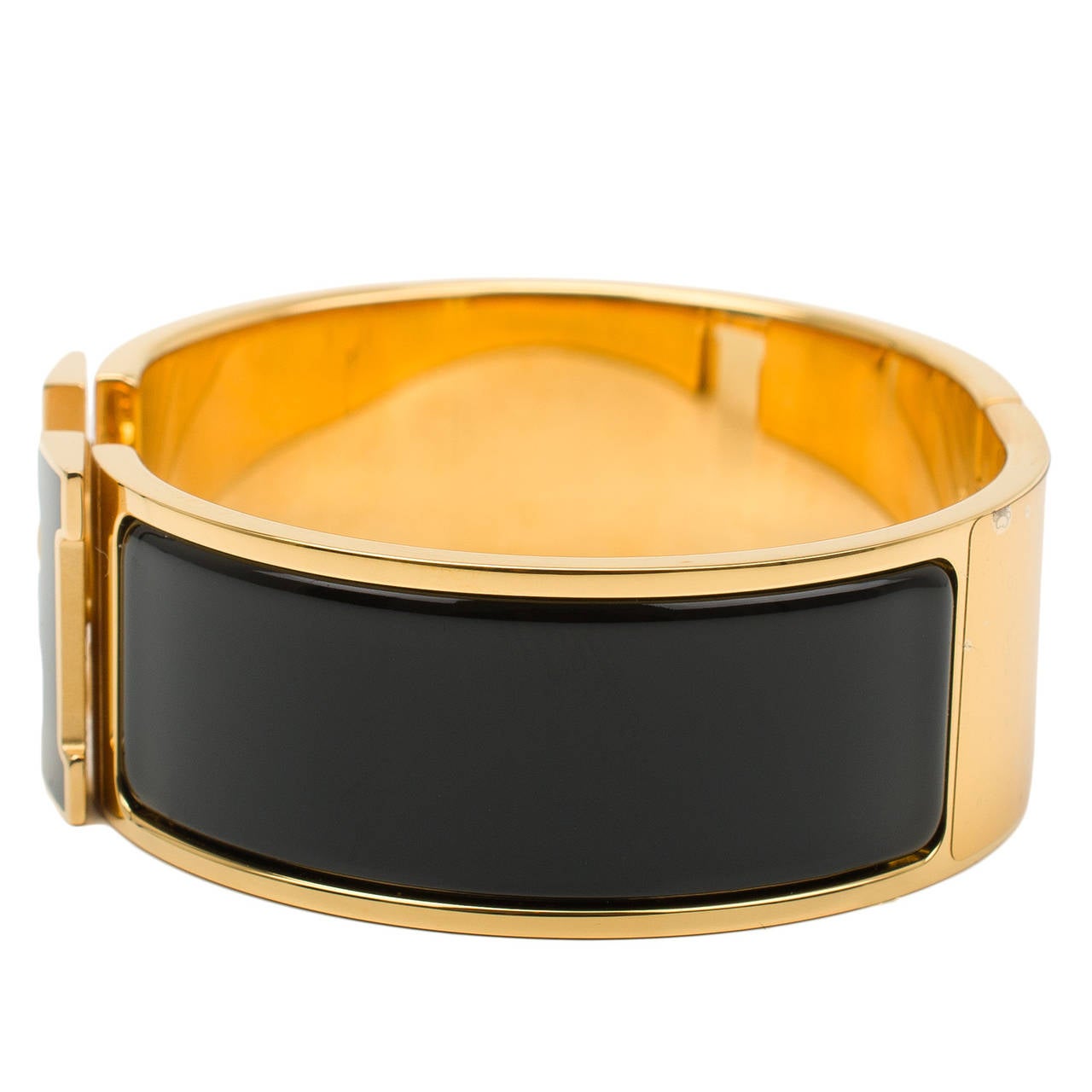 Hermes wide Clic Clac H bracelet in Black enamel with Black enamel H and gold plated hardware in size GM.

Hermes is renowned for its enamel and leather bracelets. Hermes printed enamel bangles, enamel Clic Clac H bracelets, and leather/exotic