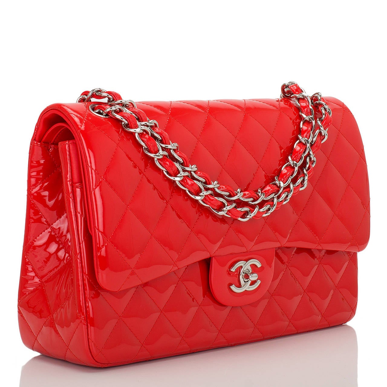 This limited edition Jumbo Classic double flap bag of bright red quilted patent leather with silver tone hardware features a full front flap with signature CC turnlock closure, half moon back pocket, and an adjustable interwoven silver tone chain