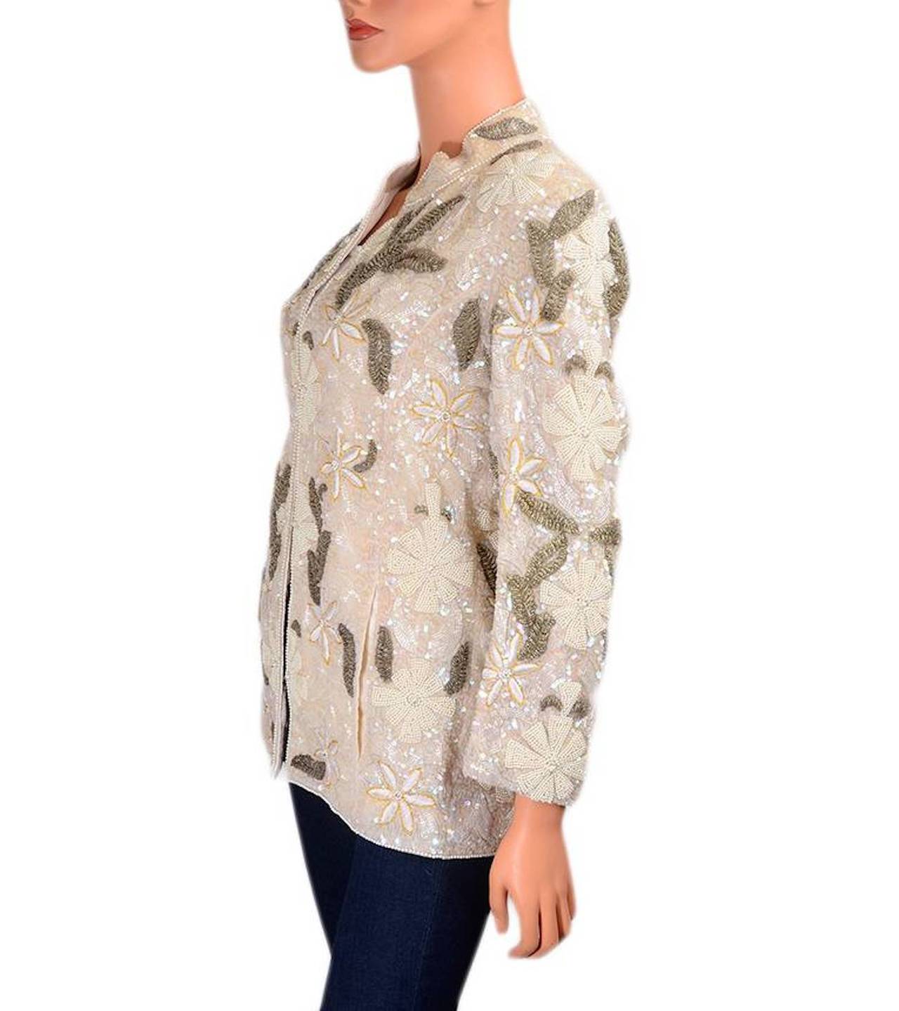 Loris Azzaro circa 1980s silk pearl iridescent and gold beaded jacket with cream embroidery, hook and eye closure, long sleeves, and silk lining.  A beautiful piece of wearable art.
 
Fabric Content: 100% silk; lining: 100% silk
 
Origin: France