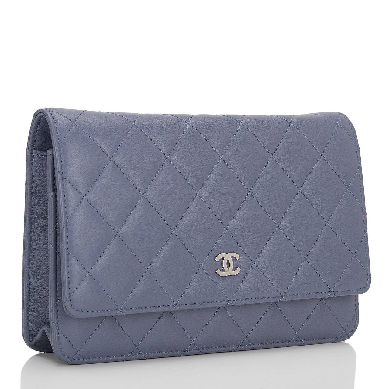 This timeless WOC in a rare lavender color lambskin leather features signature Chanel quilting, front flap with CC charm and hidden snap closure, expandable sides and bottom, half moon rear pocket and interwoven silver tone chain and leather