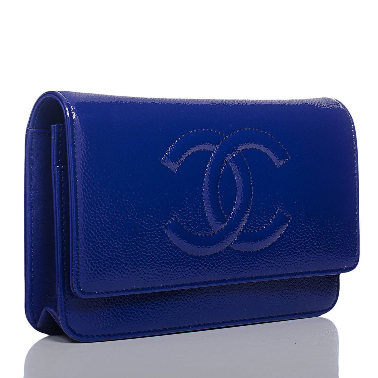 This Timeless Wallet On Chain (WOC) in a rare glazed blue caviar with ruthenium hardware features a front flap with tonal stitched large CC, hidden snap closure, expandable sides and bottom, and interwoven ruthenium and blue leather