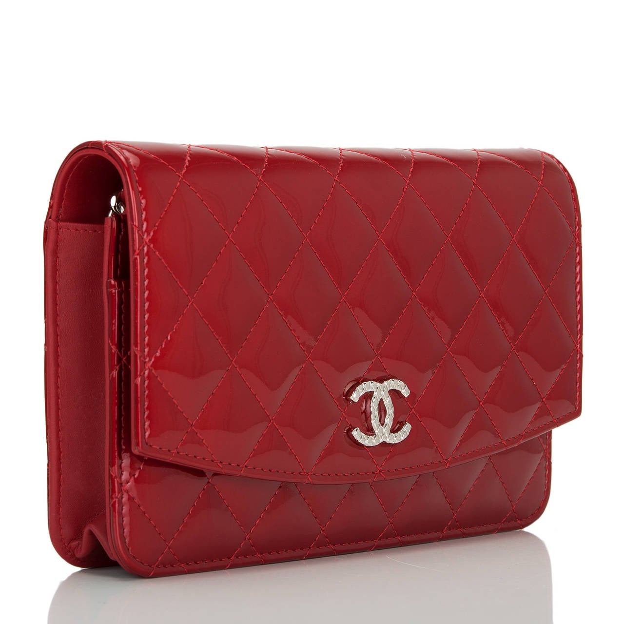 This WOC in a beautiful red color patent leather features signature Chanel quilting, front flap with CC charm and hidden snap closure, expandable sides and bottom, half moon rear pocket and interwoven silver tone chain and leather shoulder/crossbody