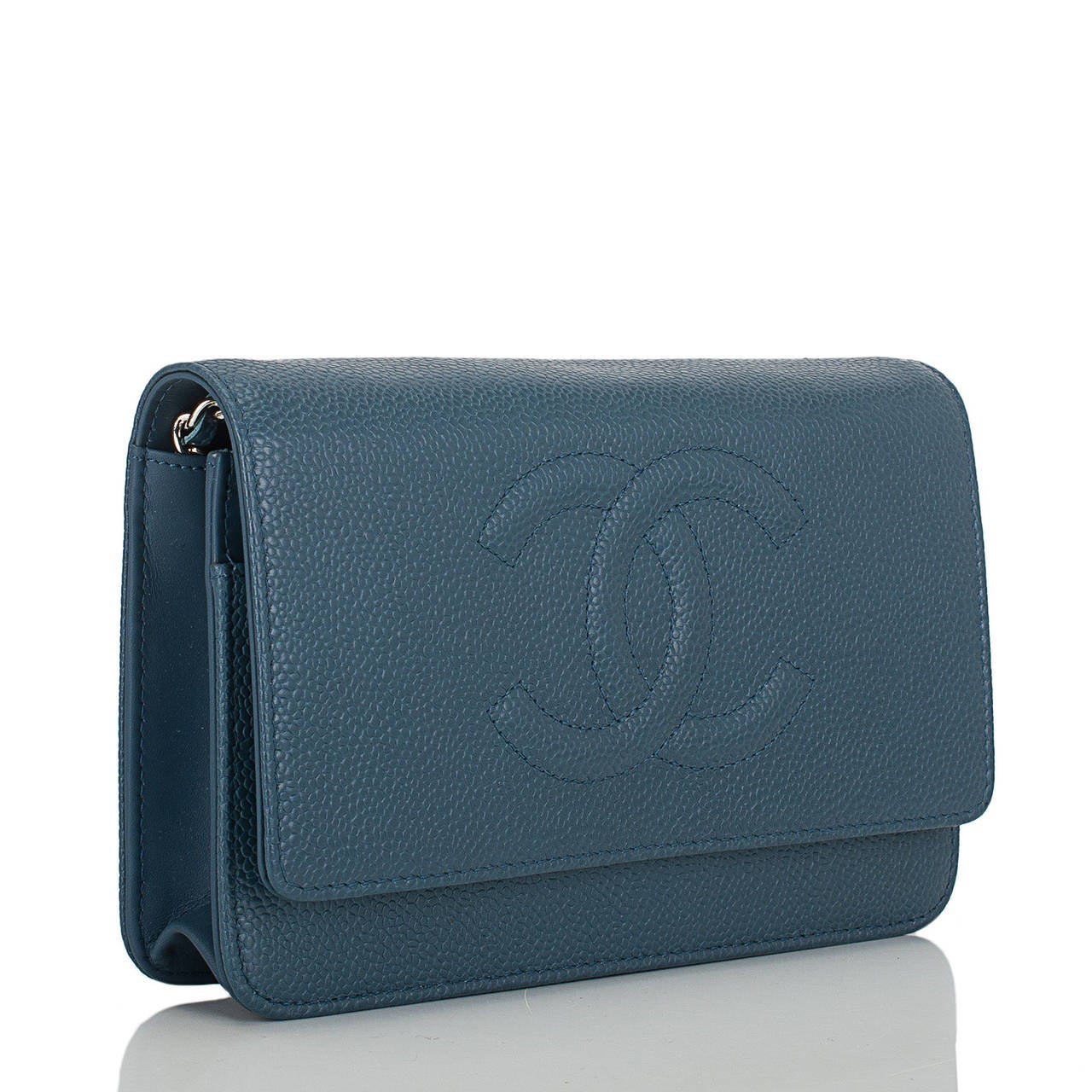 This Timeless Wallet On Chain in a rich slate blue color caviar leather features a front flap with tonal stitched large CC, hidden snap closure, expandable sides and bottom, and interwoven silver tone chain link and blue leather shoulder/crossbody