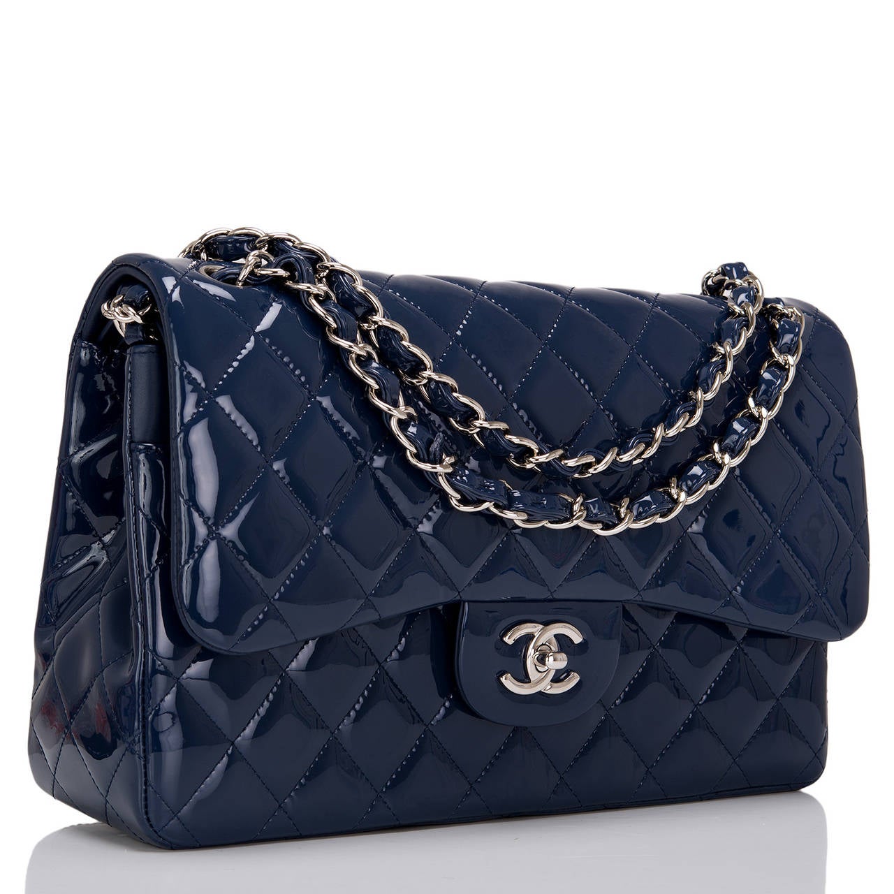 Chanel Jumbo Classic in navy blue quilted patent leather with silver tone hardware; featuring a front flap with signature CC turnlock closure, half moon back pocket, and an adjustable interwoven silver tone chain link and navy leather shoulder