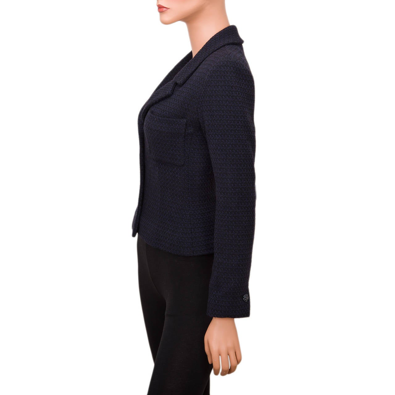 Chanel navy wool blend boucle jacket with notched collar and lapels. four navy camellia button front closure, two patch breast pockets, long sleeves with one camellia button on each and signature camellia and CC logo silk lining with weighted silver
