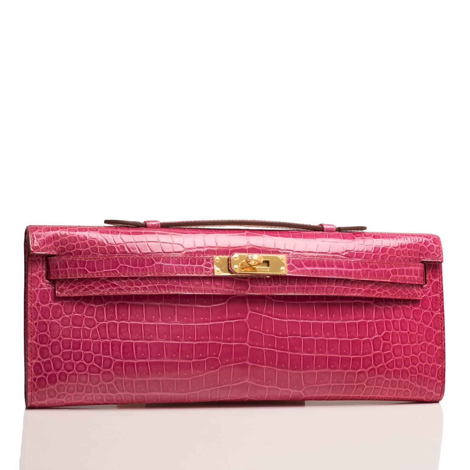 Hermes Fuchsia shiny niloticus crocodile Kelly Cut with gold hardware.

This exotic Kelly Cut has tonal stitching, front straps with toggle closure and a top flat handle.

The interior is lined in Fuchsia chevre leather and features an open wall