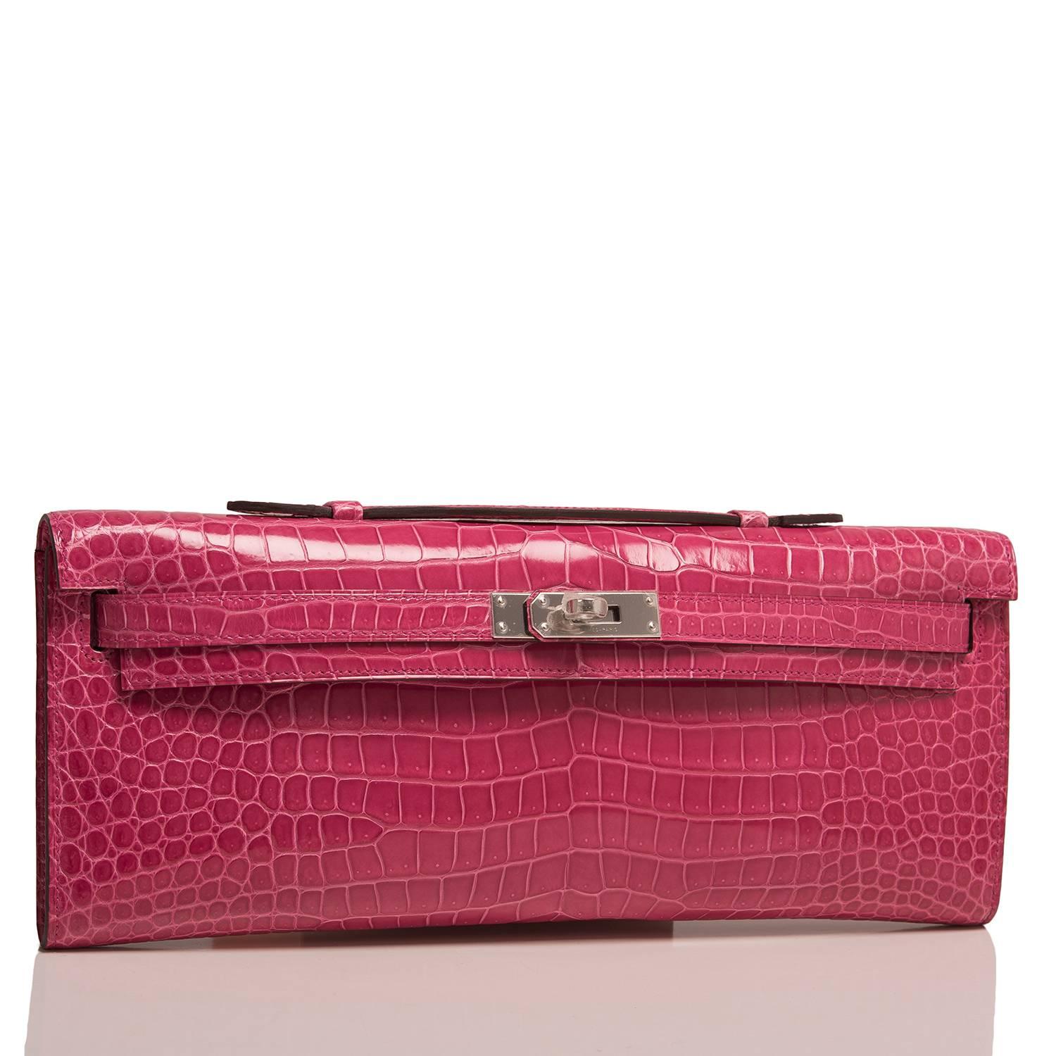 Hermes Rose Tyrien Kelly Cut of shiny porosus crocodile with palladium hardware.

This Kelly Cut has tonal stitching, front straps with a toggle closure and a top flat handle.

The interior is lined with Rose Tyrien chevre leather and features