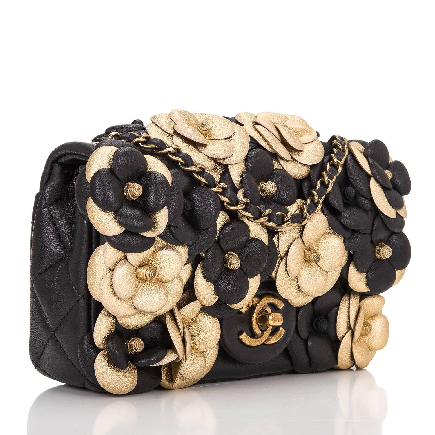 Chanel Mini Classic flap bag of black quilted lambskin leather with antique gold tone hardware.

This bag features a front flap with black and gold neoprene flower embellishments, antique CC turnlock closure and an interwoven antique gold tone