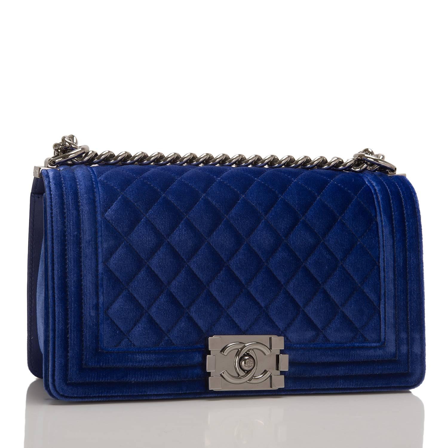 Chanel Medium Boy bag of blue velvet with ruthenium hardware.

This bag features a front flap with Le Boy CC push lock closure and a ruthenium chain link with blue leather padded shoulder strap.

The interior is lined in blue fabric with an open