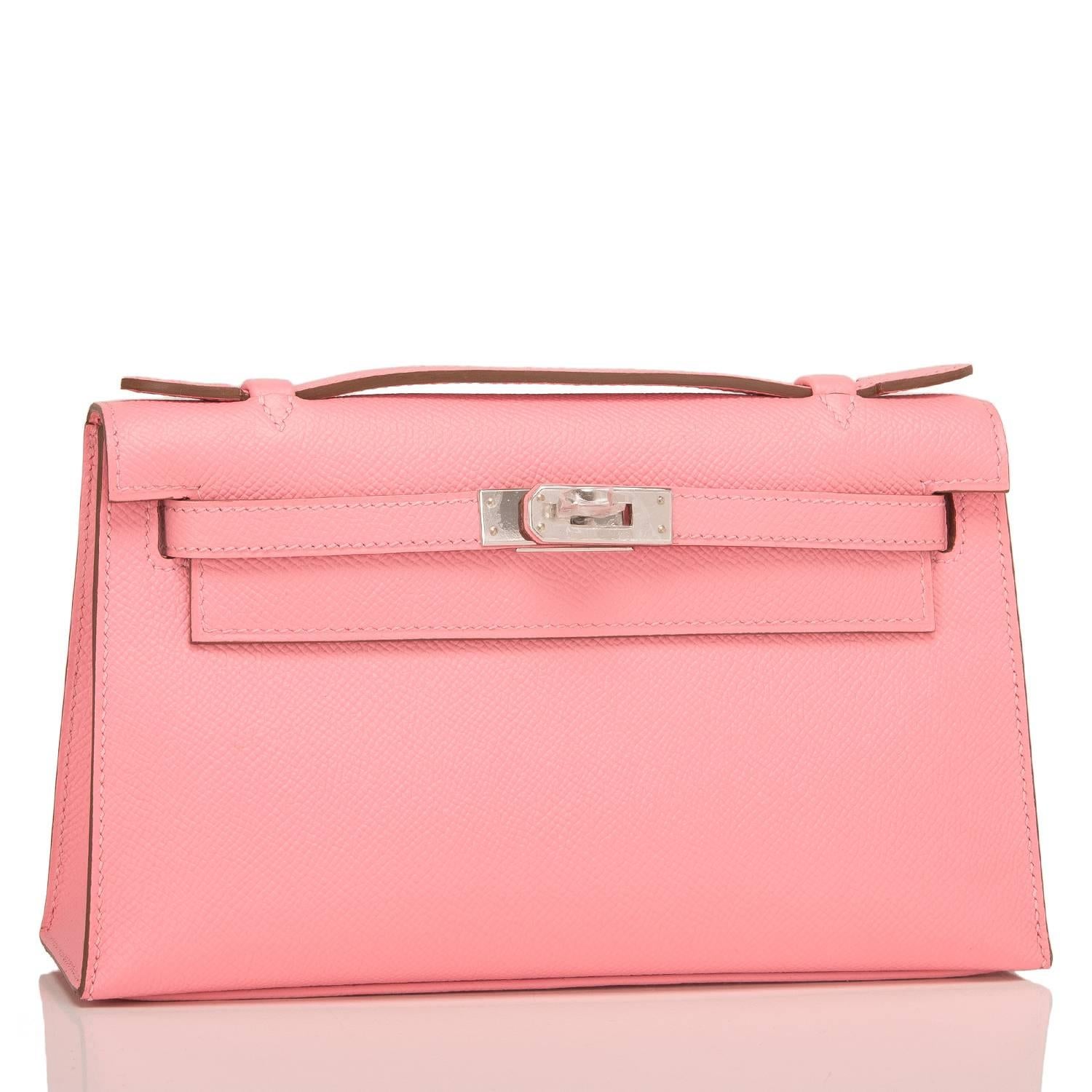 Hermes Rose Confetti Mini Kelly Pochette of epsom leather with palladium hardware.

This Hermes Kelly Pochette has tonal stitching, a front flap with two straps, a toggle closure and a single flat handle.

The interior is lined with rose