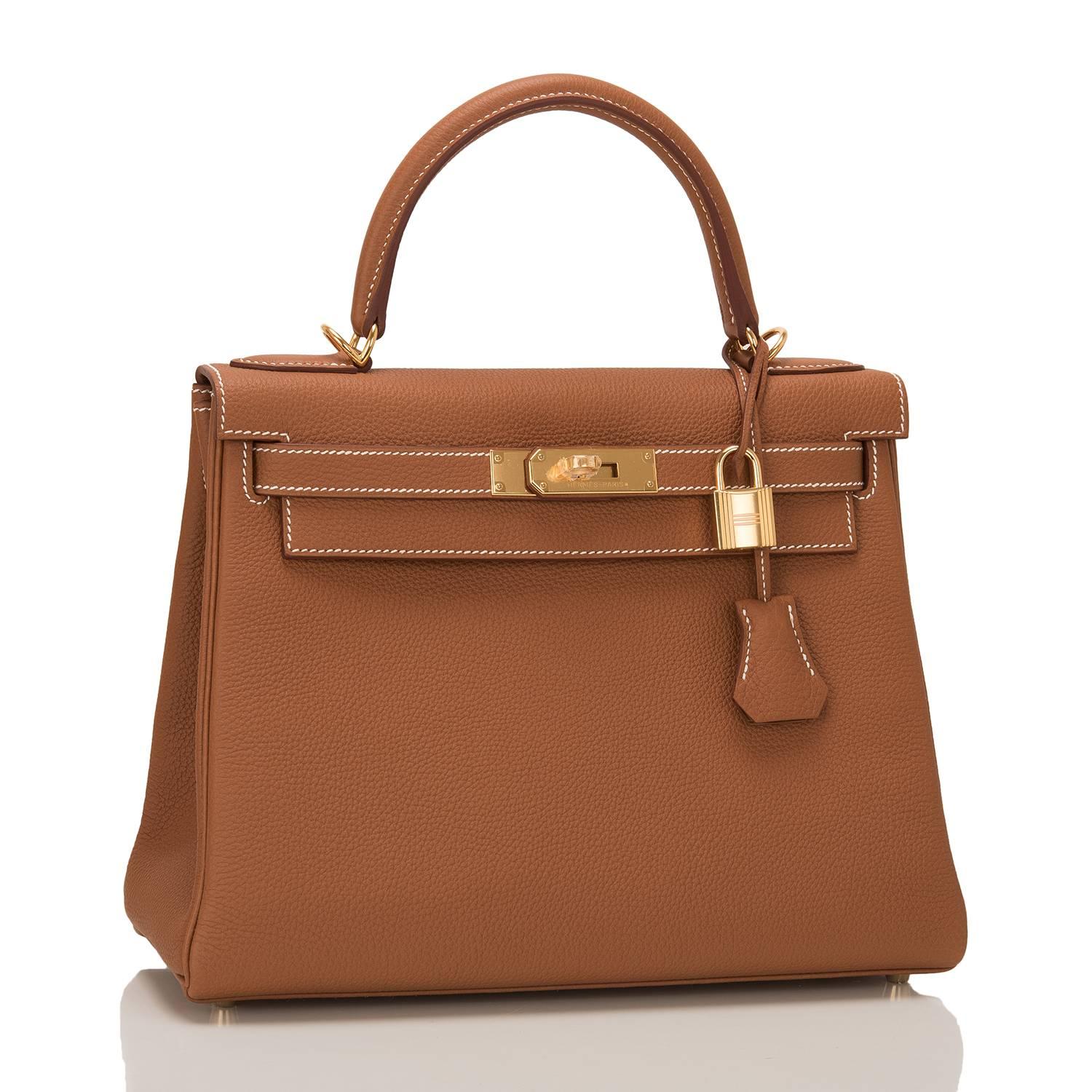 This Hermes Gold Kelly 28cm in togo leather with gold hardware.

It features white contrast stitching, front toggle closure, clochette with lock and two keys, single rolled handle and optional shoulder strap.

The interior is lined in gold