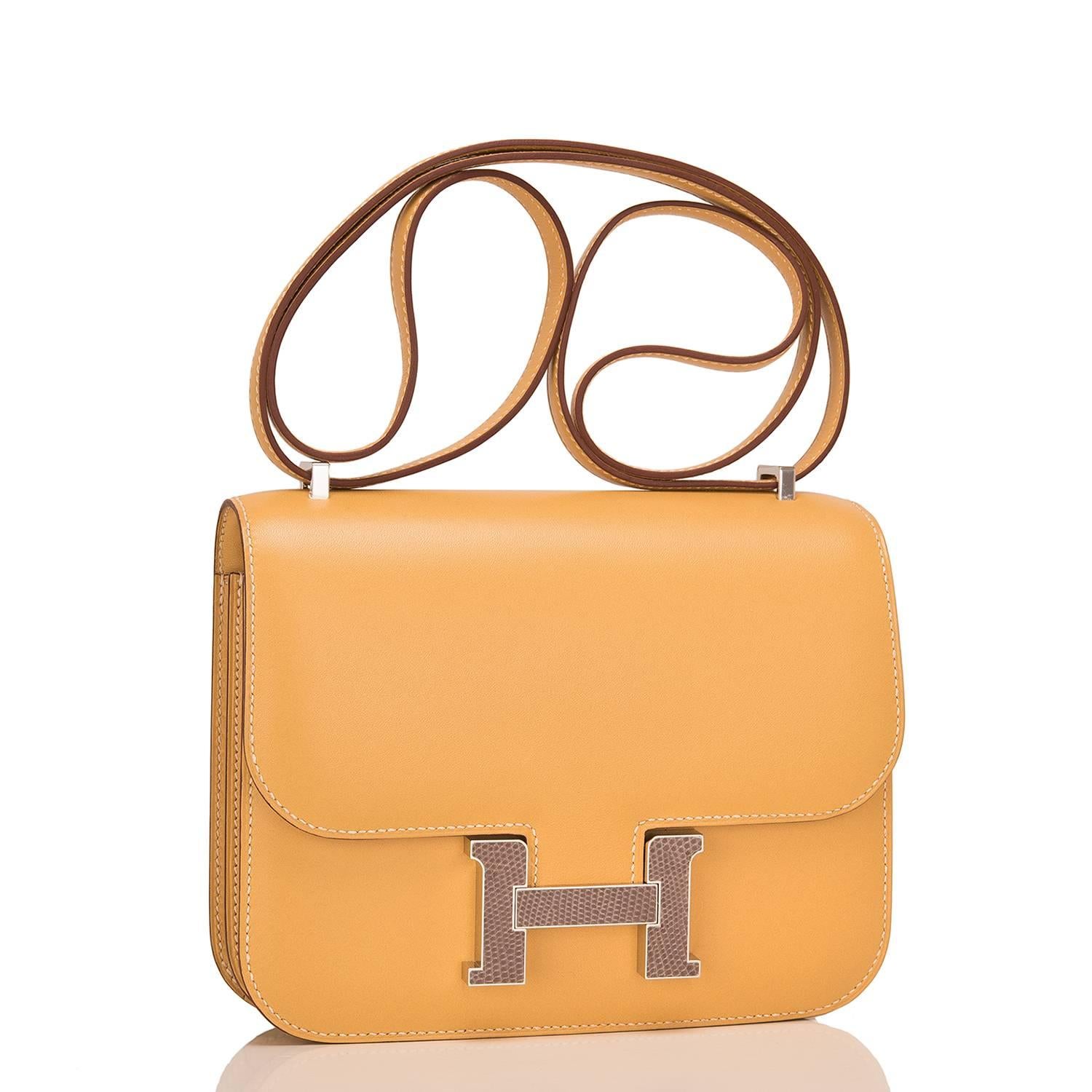 Hermes Paille Mini Constance 18cm of tadelakt leather with Agate lizard "H" snap closure and palladium hardware.

This Constance has tonal stitching, palladium hardware, a lizard "H" snap lock closure, and an adjustable
