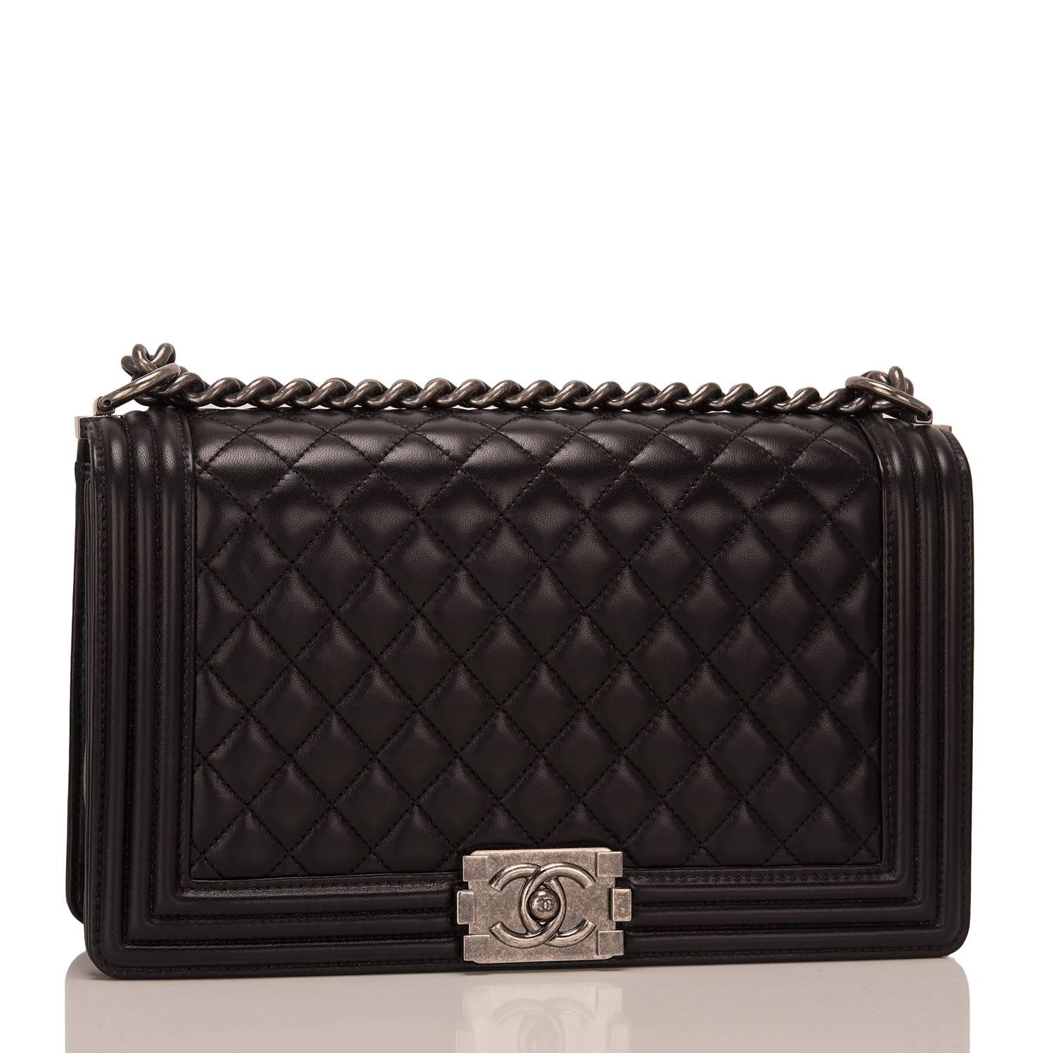 Chanel New Medium Boy bag of black lambskin leather with aged ruthenium hardware.

This bag features a full front flap with the Le Boy CC push lock closure and an aged ruthenium chain link and black leather padded shoulder/crossbody strap.

The