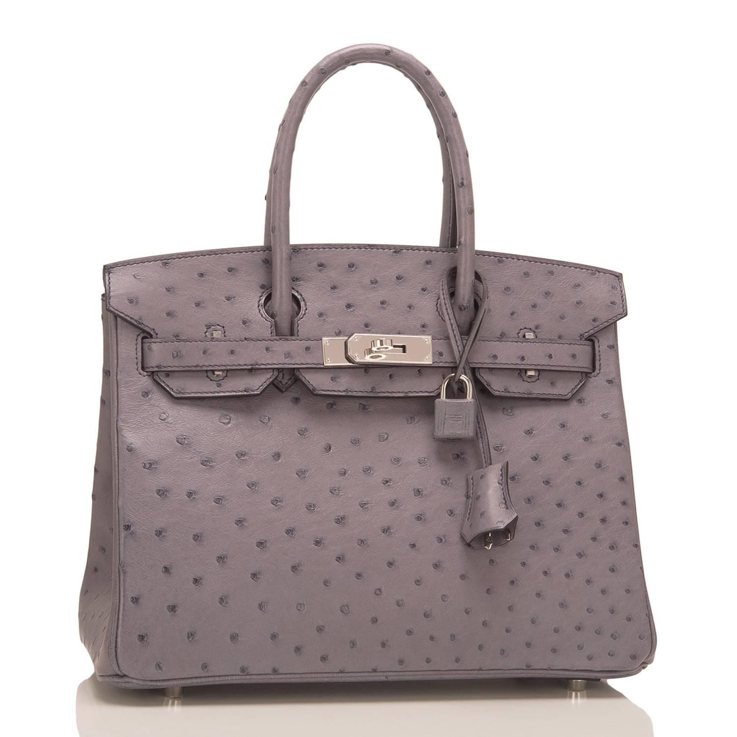 Hermes Gris Agate Birkin 30cm of Ostrich with palladium hardware.

This Birkin has tonal stitching, a front toggle closure, a clochette with lock and two keys, and double rolled handles.

The interior is lined with Gris Agate chevre and has a