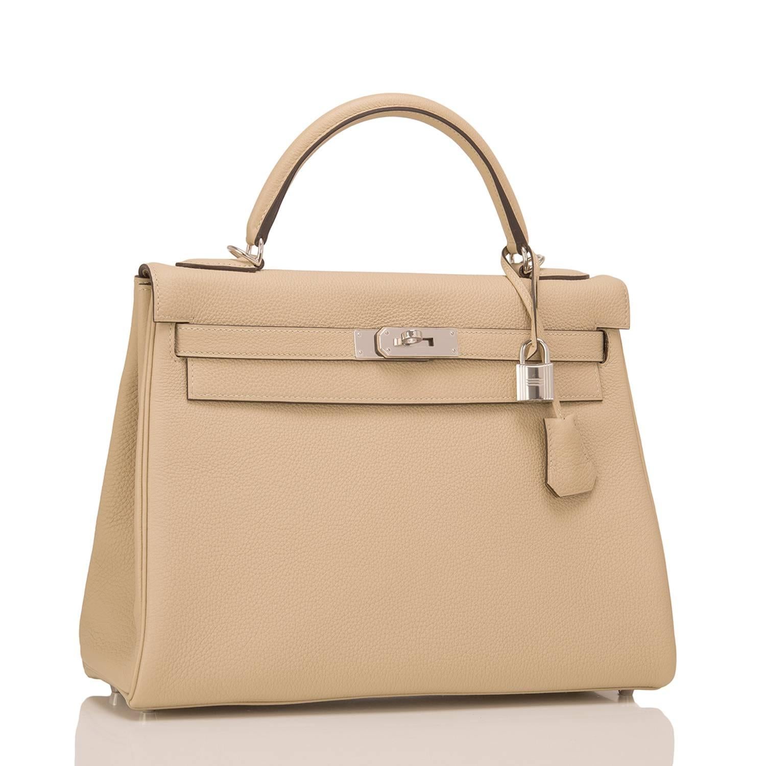 Hermes Trench Kelly 32cm of togo leather with palladium hardware.

This Kelly, in the Retourne style, has tonal stitching, a front toggle closure, a clochette with lock and two keys, a single rolled handle, and a removable shoulder strap.

The