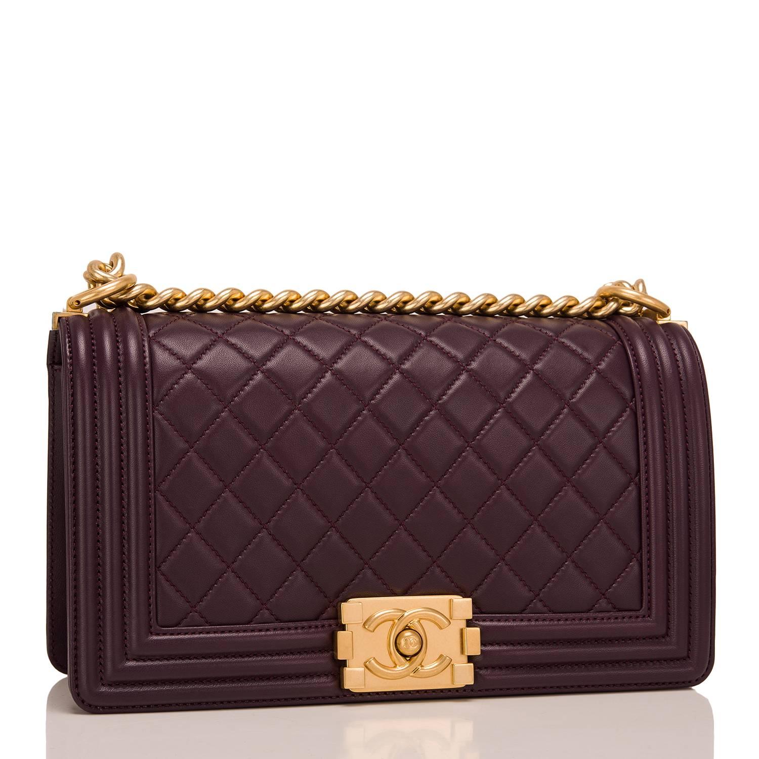 Chanel Old Medium Boy bag of dark purple quilted lambskin and gold hardware.

This Chanel bag is in the classic Boy style with a full front flap with the Boy signature CC push lock closure detail and gold chain link and dark purple leather padded