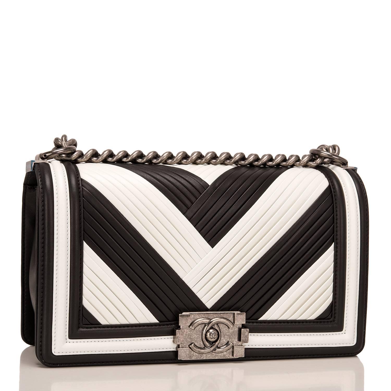 Chanel Paris In Rome Metiers d'Art Medium Boy bag of black and white pleated calfskin with ruthenium hardware.

This limited edition Chanel bag is in the classic Boy style with a full front flap with the Boy signature CC push lock closure detail