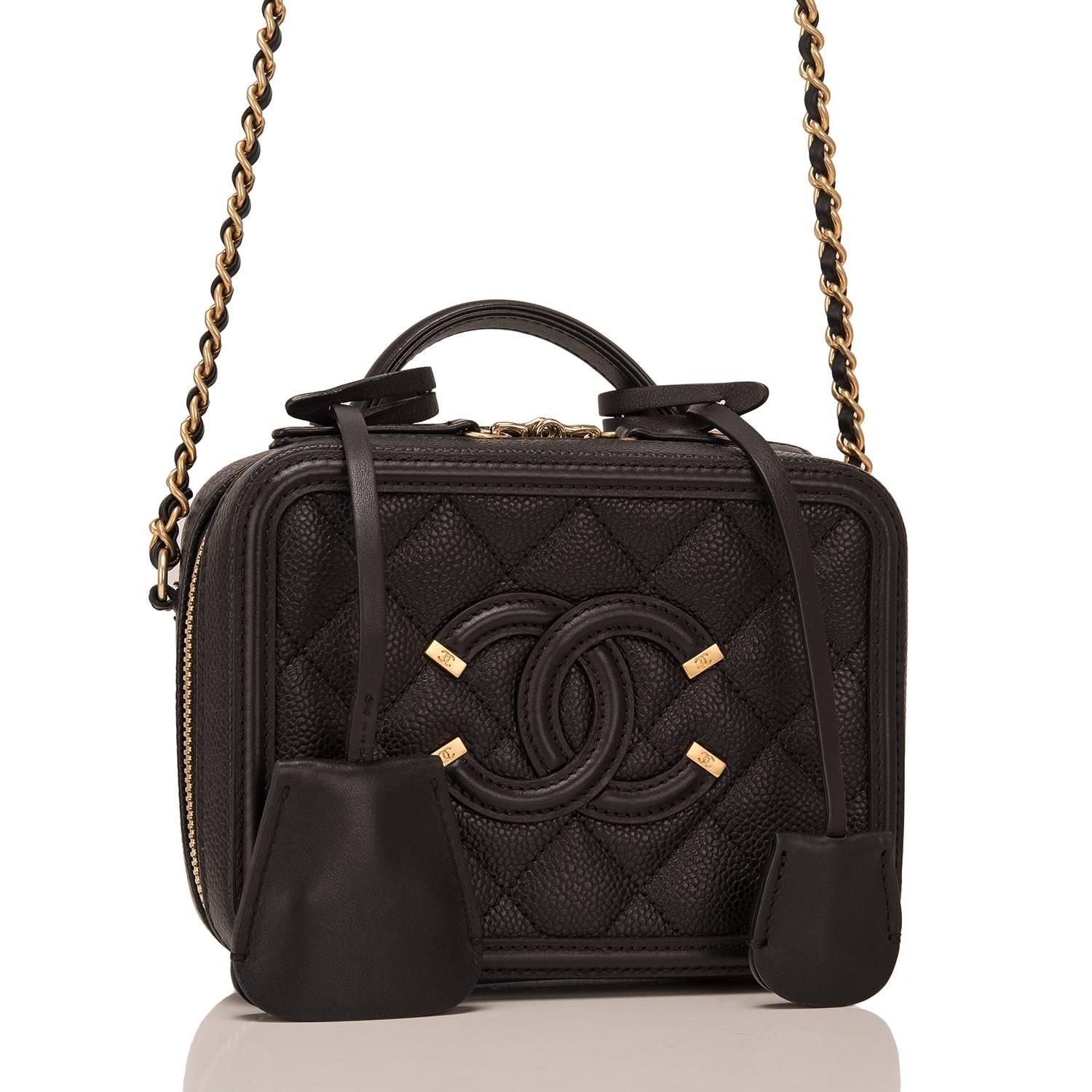 Chanel Mini Filigree Vanity Case of black caviar leather with gold tone hardware.

This bag features Chanel's signature CC logo stitch in on the front, a gold tone CC lock with a clochette, a matching key with another clochette, zip around