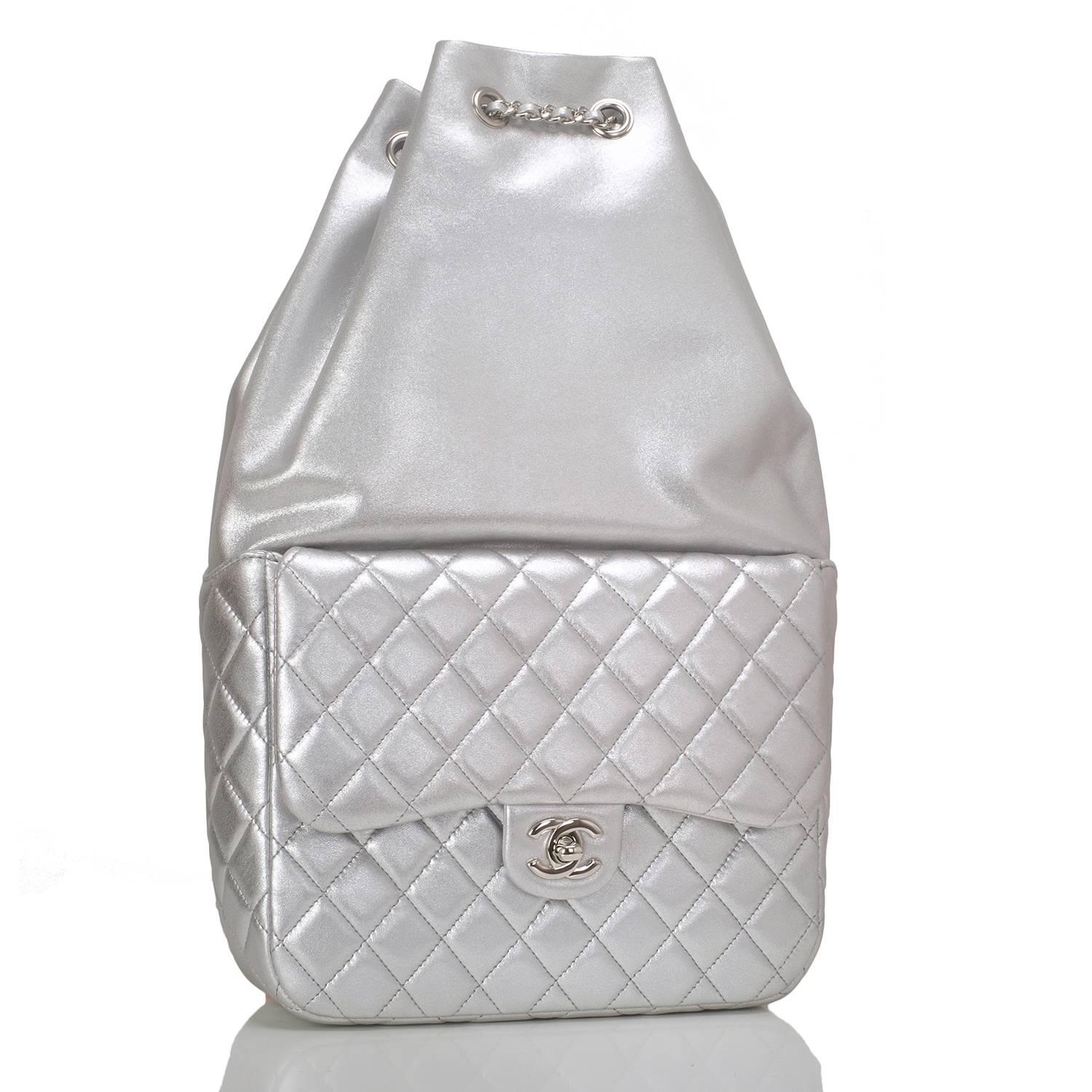 Chanel backpack of silver metallic lambskin leather with silver tone tone hardware.

This backpack has a front quilted leather flap pocket with a signature CC turnlock closure, a top cinch closure, and interwoven silver tone chain link with dark