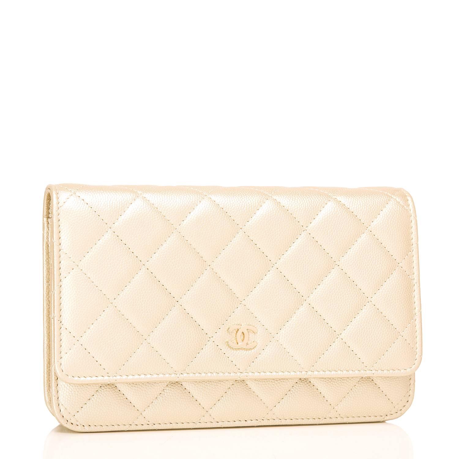 Chanel Classic Wallet on Chain (WOC) of gold caviar leather with gold tone hardware.

This Wallet On Chain features signature Chanel quilting, a front flap with CC charm and hidden snap closure, a half moon rear pocket and an interwoven gold tone