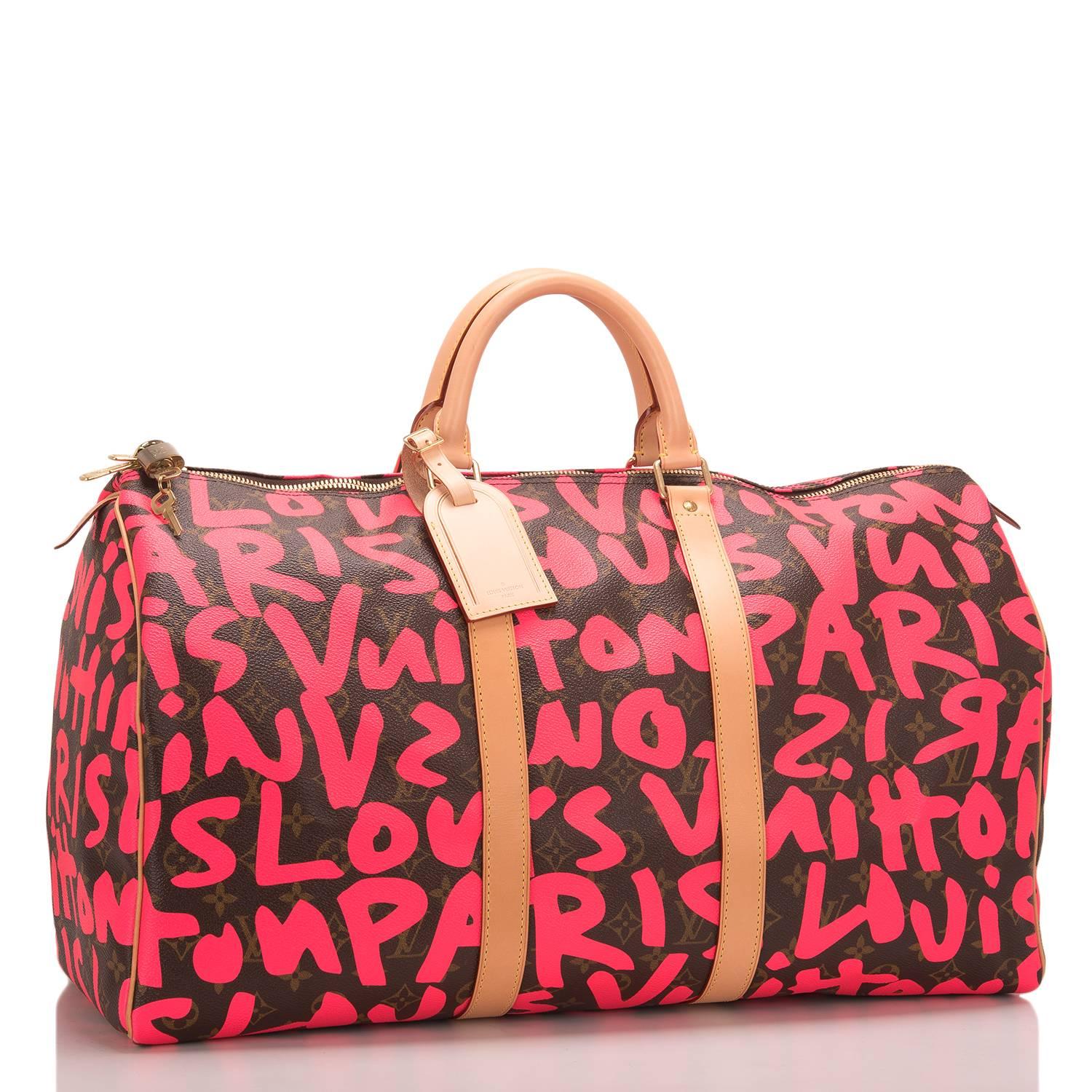 Louis Vuitton Pink Monogram Graffiti Keepall 50 of coated canvas with silk screened bright fluorescent pink colored graffiti lettering designed in tribute to Stephen Sprouse.

This classic travel bag features polished brass hardware, vachetta