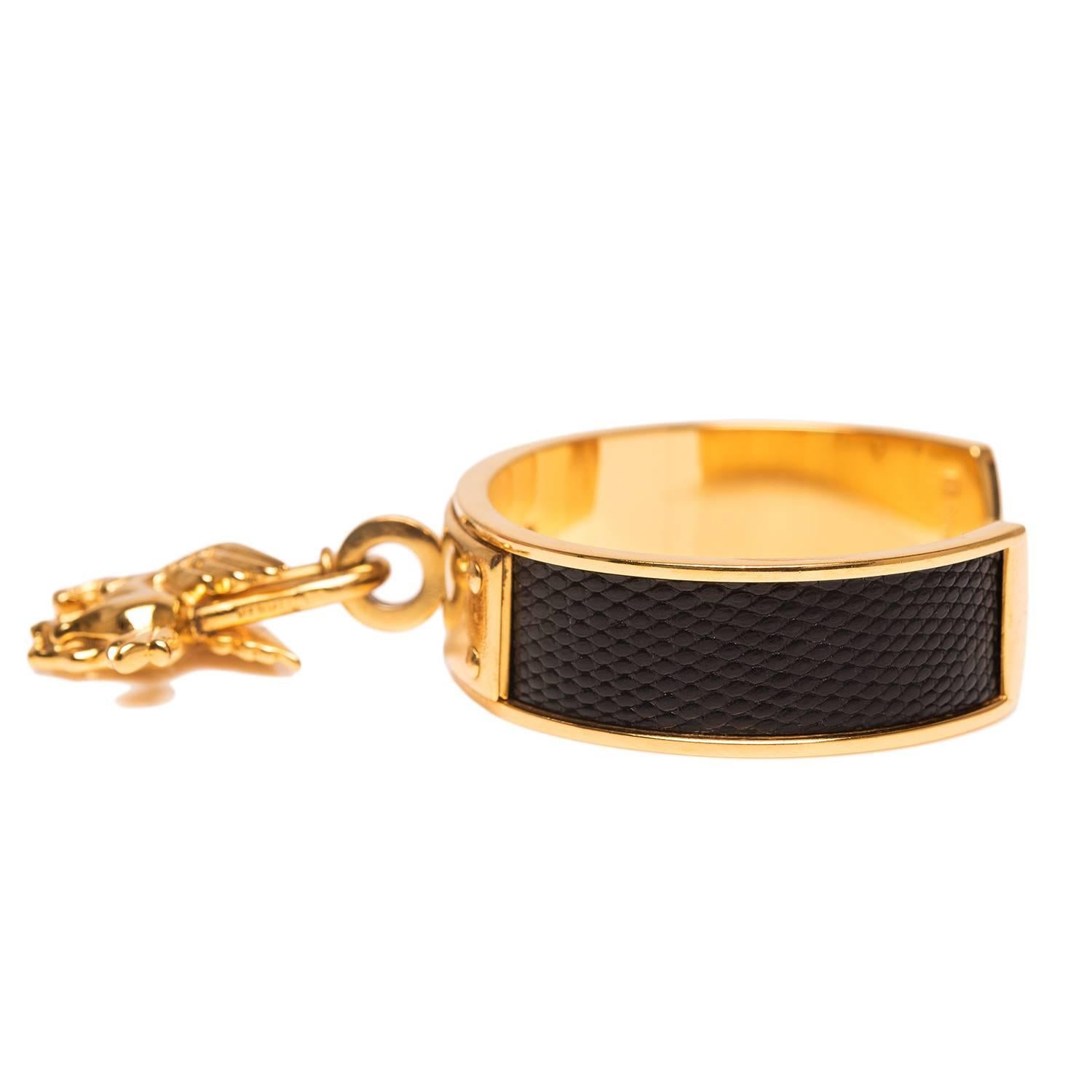 Hermes Black Lizard Kelly Cadena Cuff Bracelet with Gold Pegasus Charm.

This bracelet is made of black lizard with gold plated hardware.

Origin: France

Condition: Pre-owned; excellent

Accompanied by: Hermes box

Measurements: Bracelet: