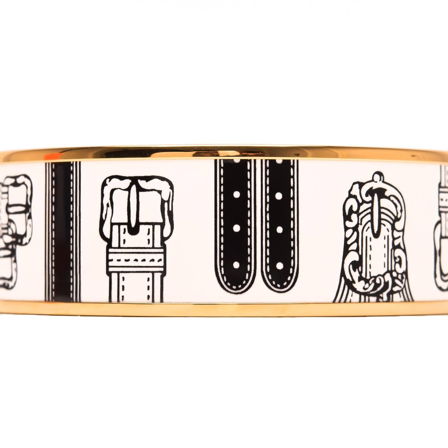 Hermes "Harnais Des Presidents" wide printed enamel bracelet size PM (65).

This bracelet depicts black harnesses on a white colored background with gold metal hardware.

Origin: France

Condition: Pristine, never worn

Accompanied