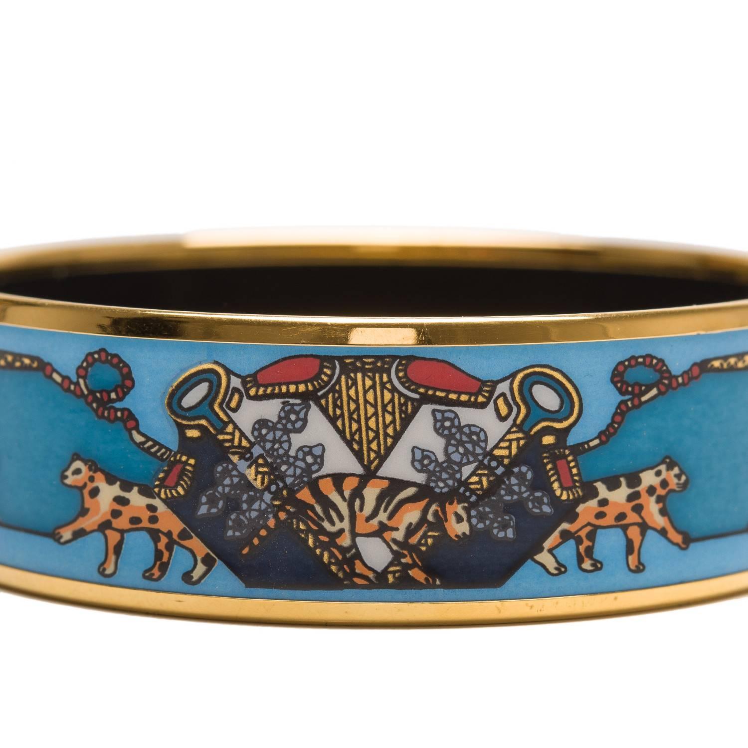 Hermes "Snow Leopards" Wide enamel bracelet size PM (65).

This bracelet depicts a Central Asian theme of two green decorative flags with a tiger at center and snow leopards on each side in a shades of blue backaground with gold plated