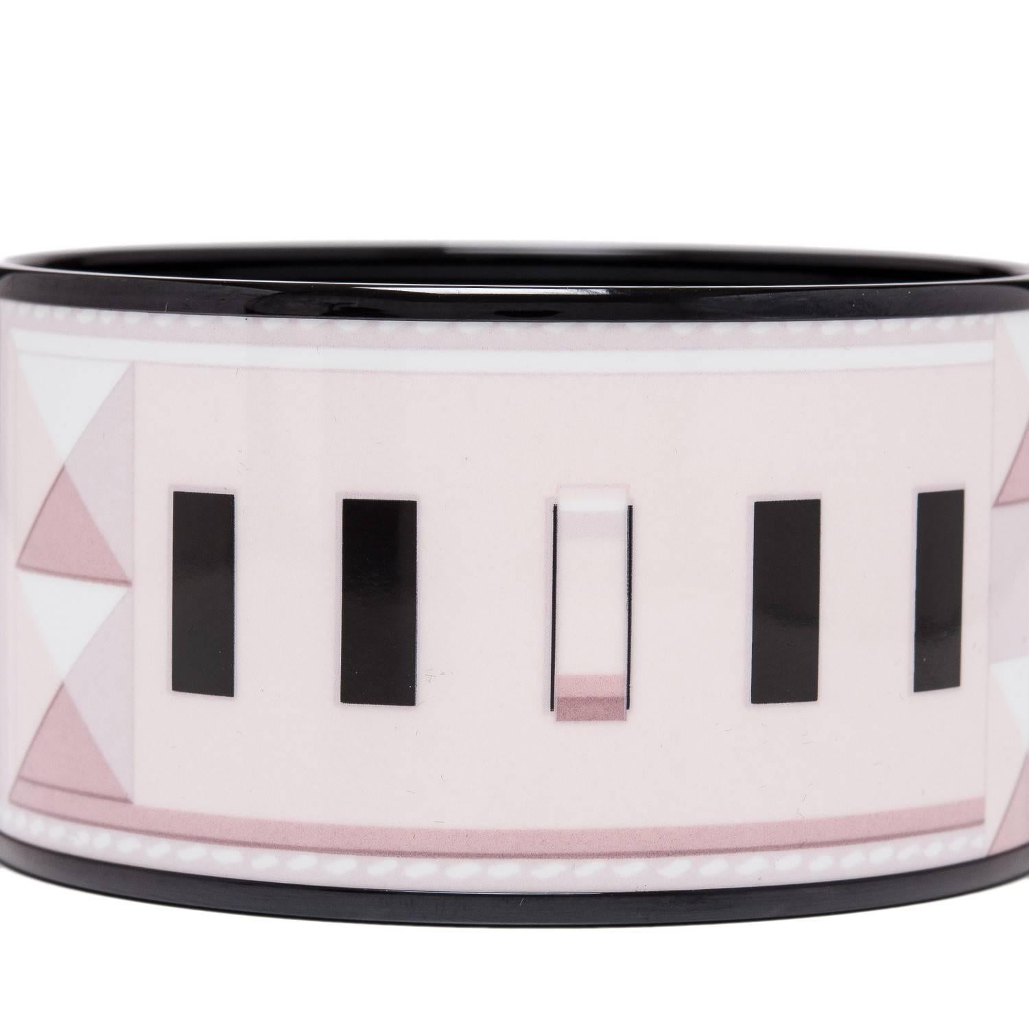 Hermes "Collier de Chiens" extra wide printed enamel bracelet size PM (65).

This bracelet depicts the Hermes Collier de Chien leather cuff on a pink colored background with black pvd hardware.

Origin: France

Condition: Pristine,