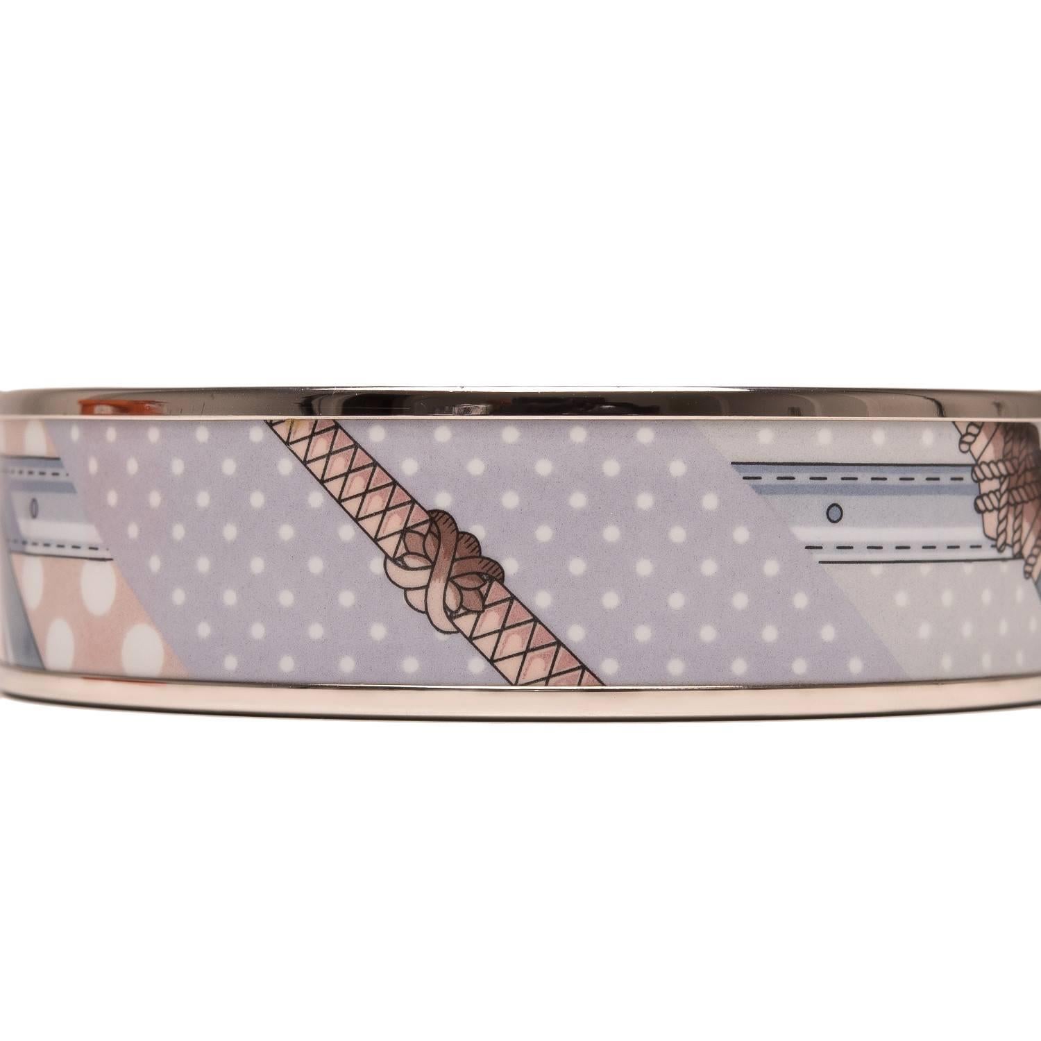 Hermes "Clic Clac a Pois" wide printed enamel bracelet size PM (65).

This bracelet depicts a blue belt, with rope detailing on a pink and white polka dot background.

Origin: France

Condition: Mint

Accompanied by: Hermes