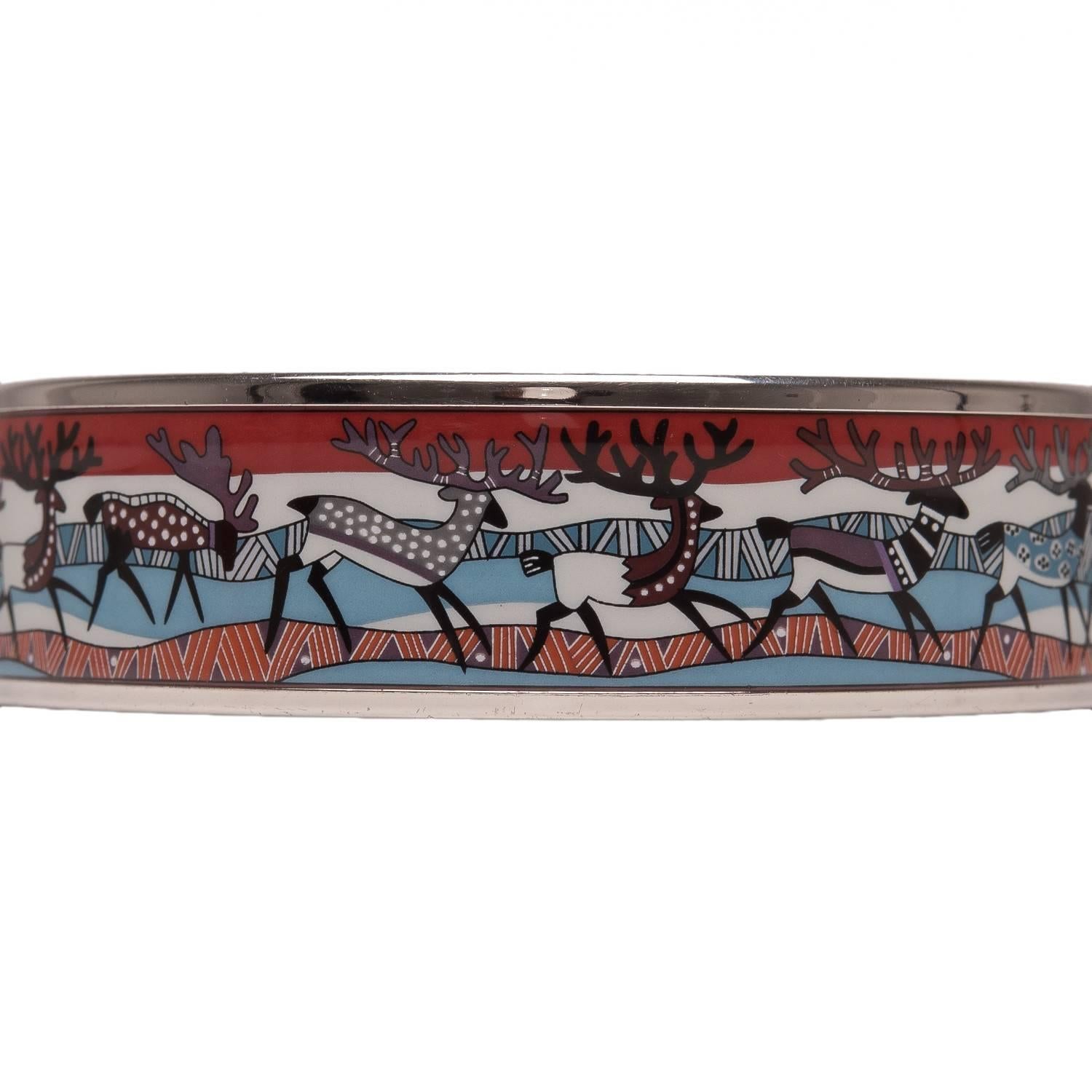 Hermes "Reindeer" wide printed enamel bracelet size PM (65).

This bracelet depicts reindeer walking together on a multicolored background with palladium hardware. 

Origin: Austria

Condition: Mint

Accompanied by: Hermes