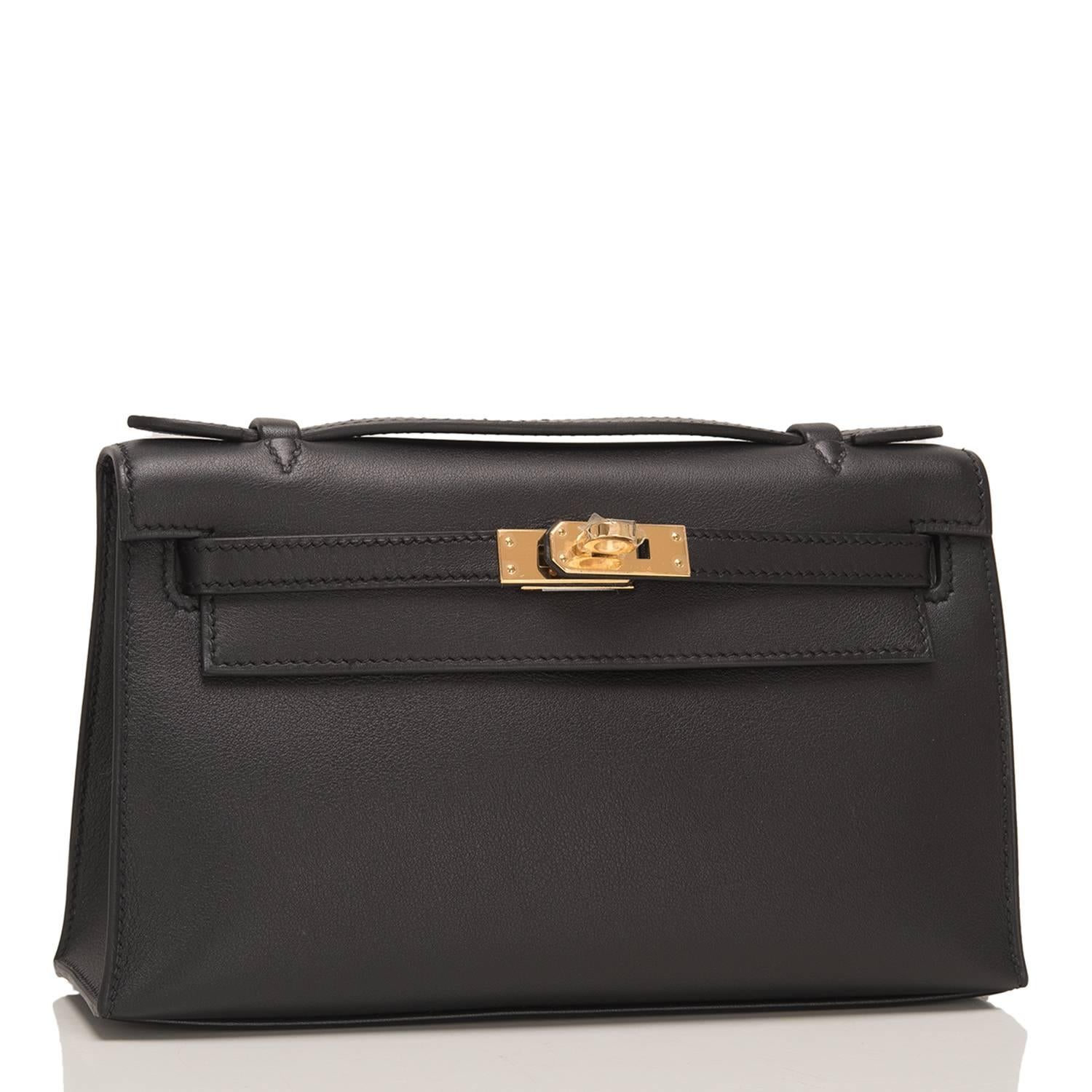 Hermes Black Mini Kelly Pochette of swift leather with gold hardware.

This Hermes pochette has tonal stitching, a front flap with two straps, a toggle closure and a single flat handle.

The interior is lined with black chevre and has one wall