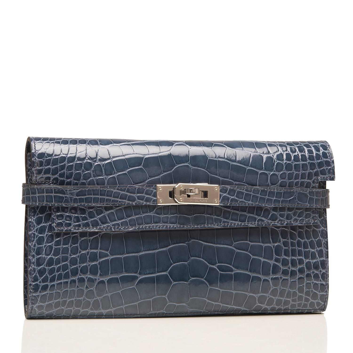 Hermes Blue Tempete Kelly Longue Wallet in shiny alligator with palladium hardware.

This exotic wallet, which can be used as a clutch, has tonal stitching, palladium hardware, and a front toggle closure.

The interior is lined with Blue Tempete