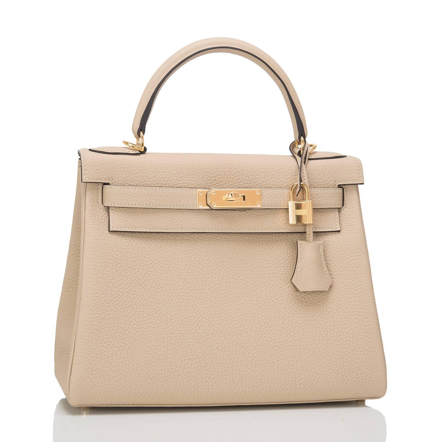 Hermes Trench Kelly 28cm of togo leather with gold hardware.

This Kelly in the Retourne style has tonal stitching, a front toggle closure, a clochette with lock and two keys, a single rolled handle, and a removable shoulder strap.

The Interior