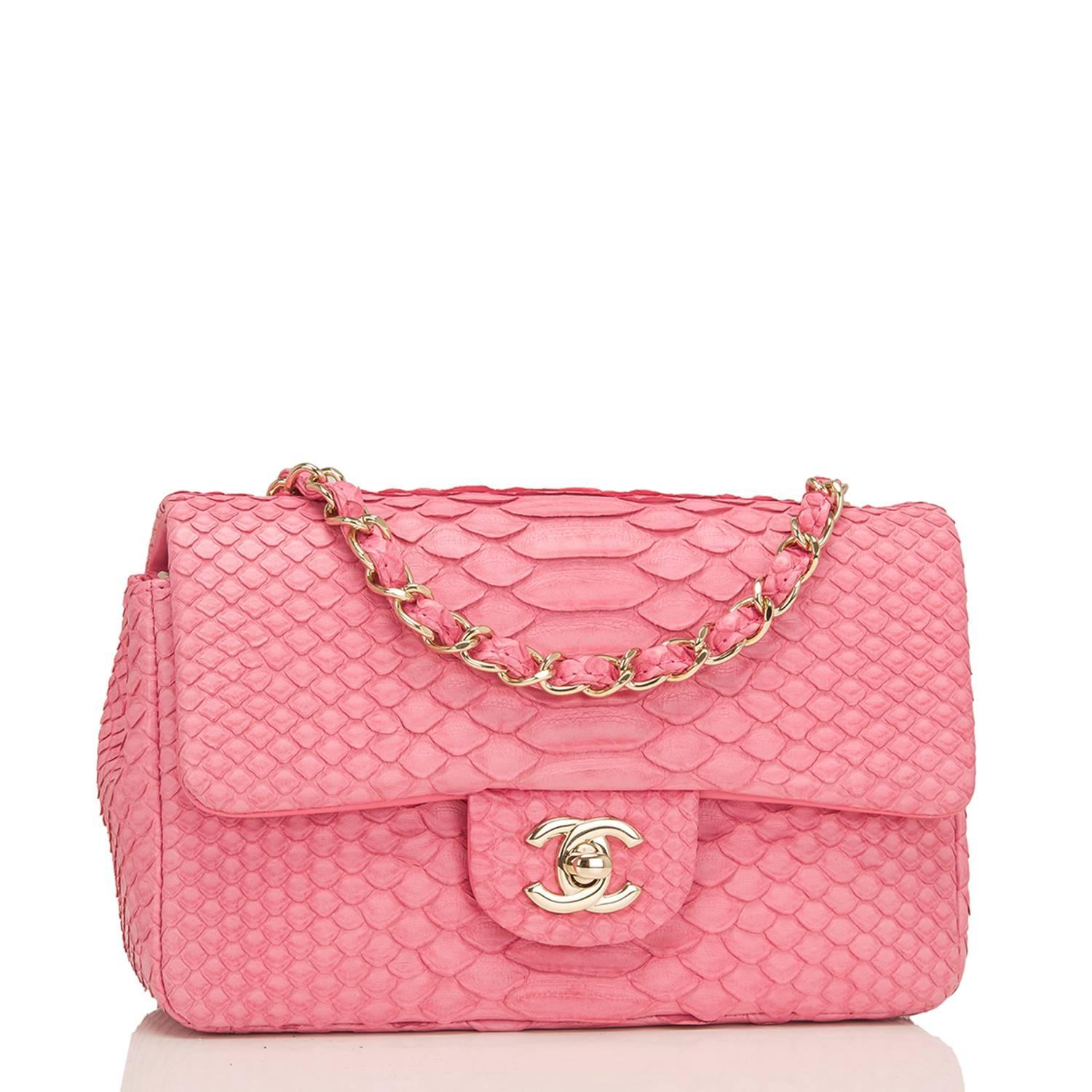 Chanel Rectangular Mini Classic flap bag of pink python with gold tone hardware.

This bag has a front flap with signature CC turnlock closure, rear half moon pocket and single interwoven pink leather and gold tone chain link shoulder/crossbody