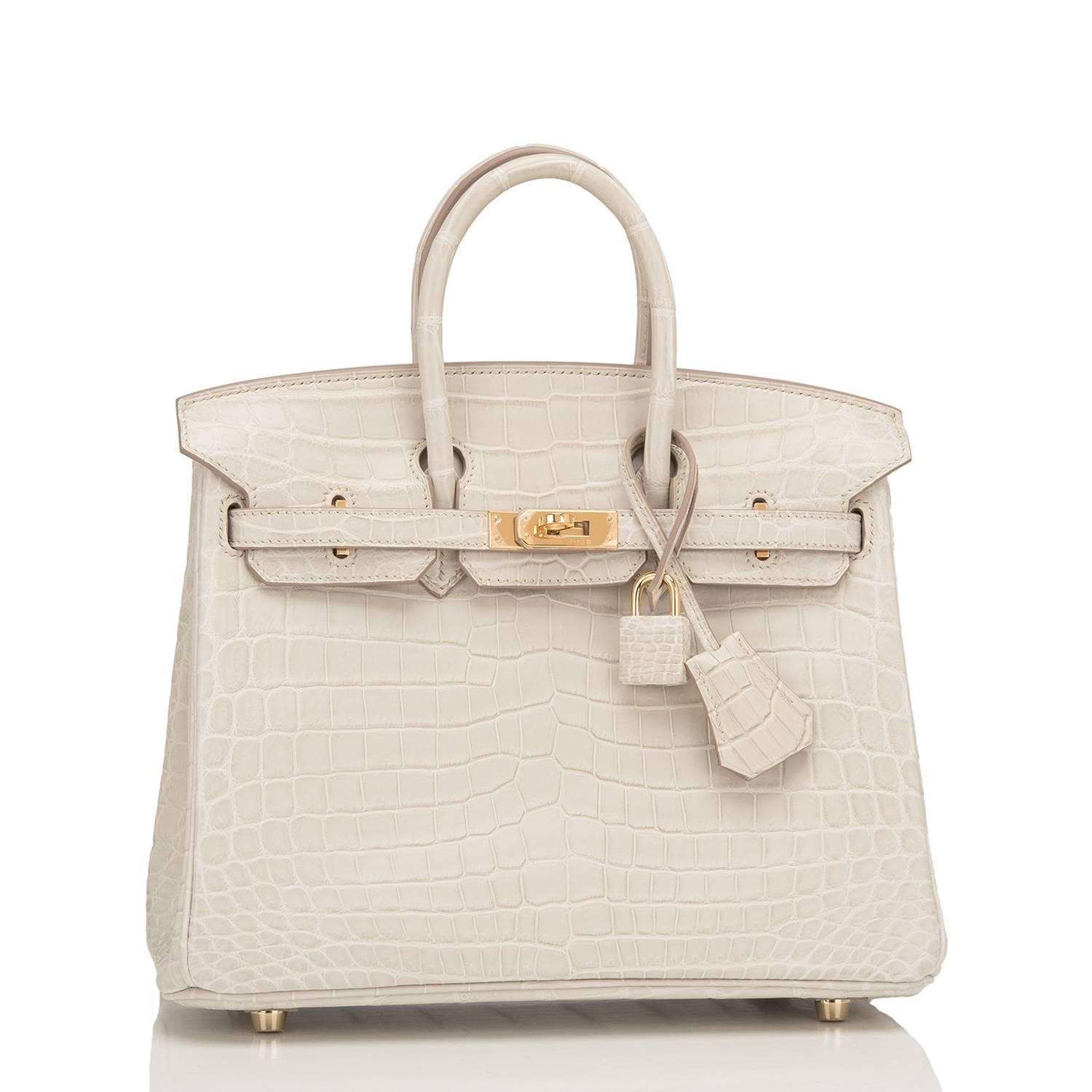 Hermes Beton Birkin 25cm in matte Nilo crocodile with gold hardware.

This Birkin has tonal stitching, a front toggle closure, a clochette with lock and two keys, and double rolled handles.

The interior is lined with Beton chevre and has one