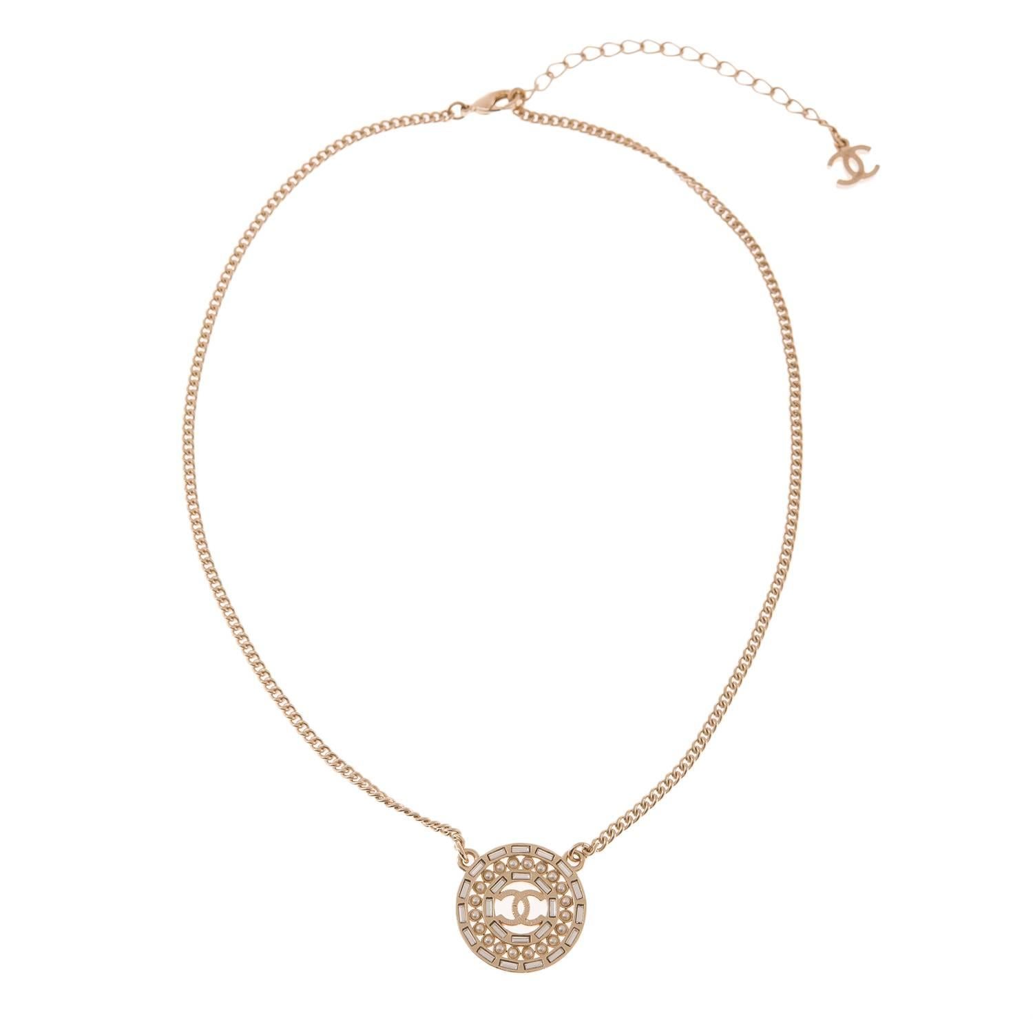 Chanel matte gold tone metal necklace with faux pearls and crystal accents.

This limited edition necklace has a one-inch round matte gold tone pendant with a layer of embedded faux pearls surrounded by layers of embedded crystals and Florentine